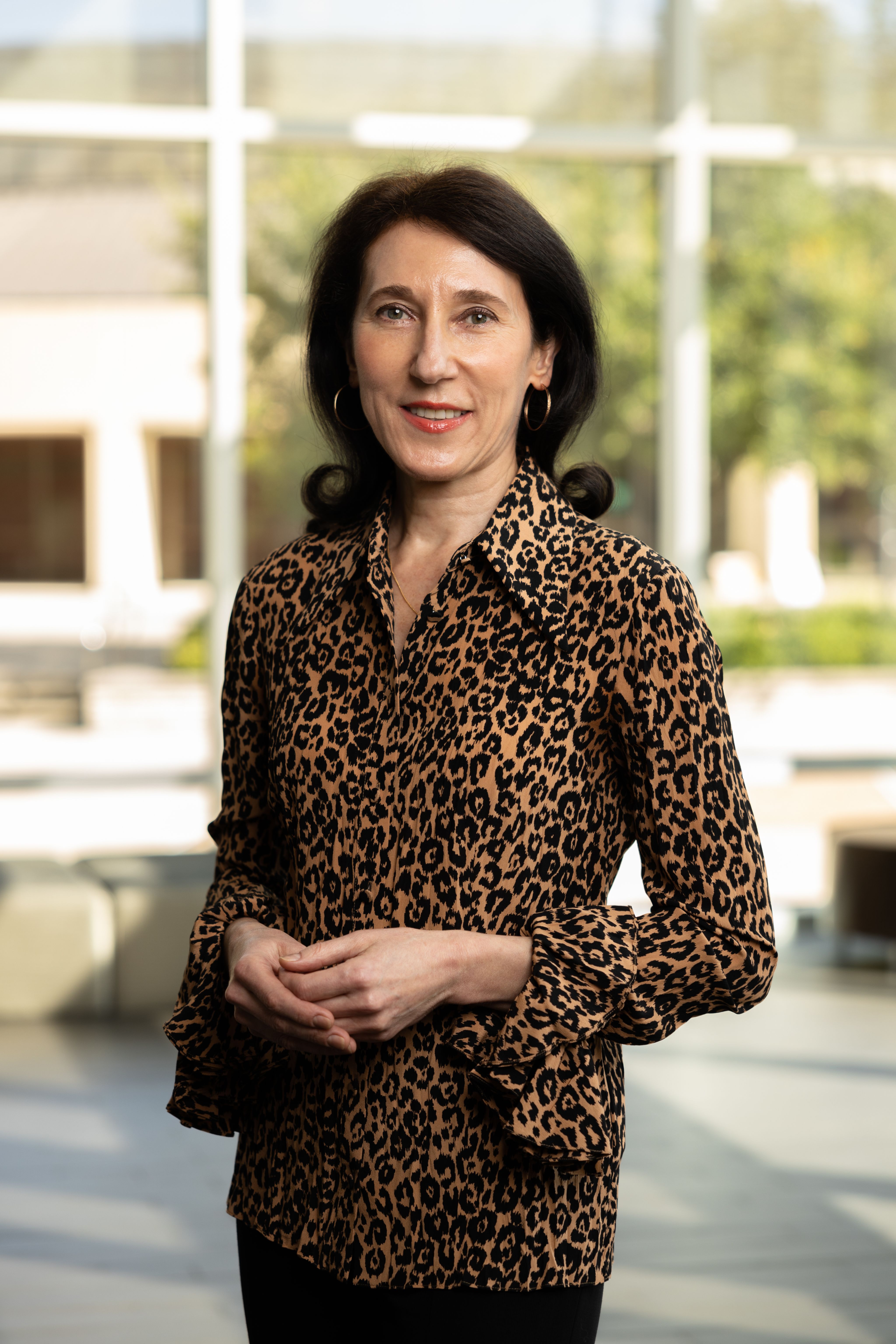 Tanya Hoogeveen stand with hands clasped in front of her for a portrait.