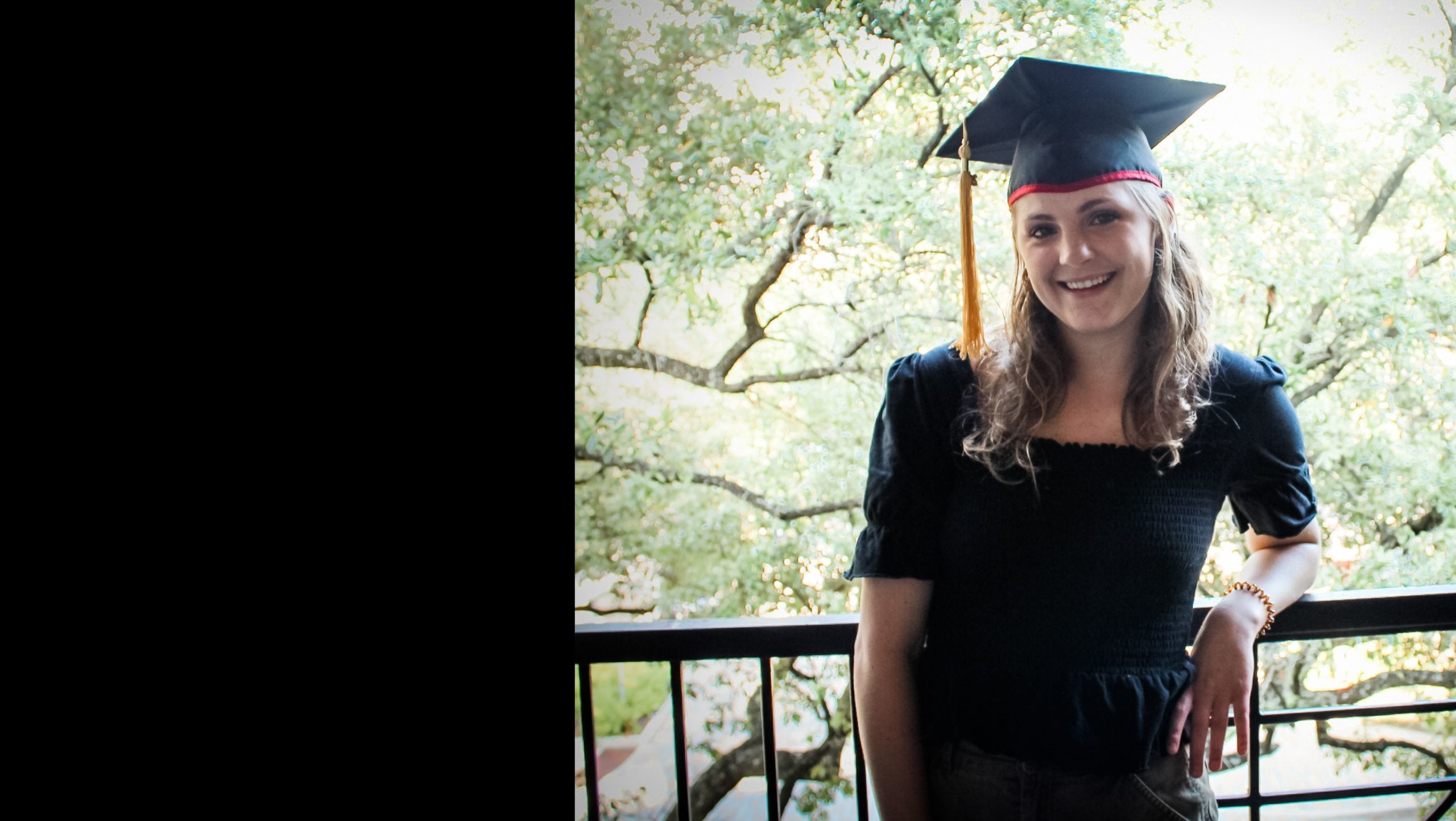 female graduate Mary Catherine McReynolds on balcony wearing grad cap