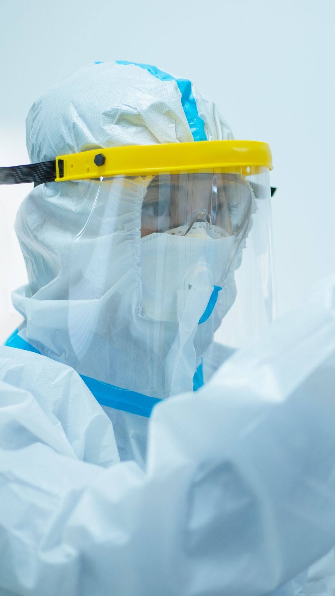 female nurse with face shield and protective suit