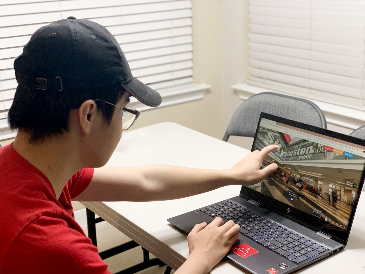 Brian Tan sitting at desk with laptop