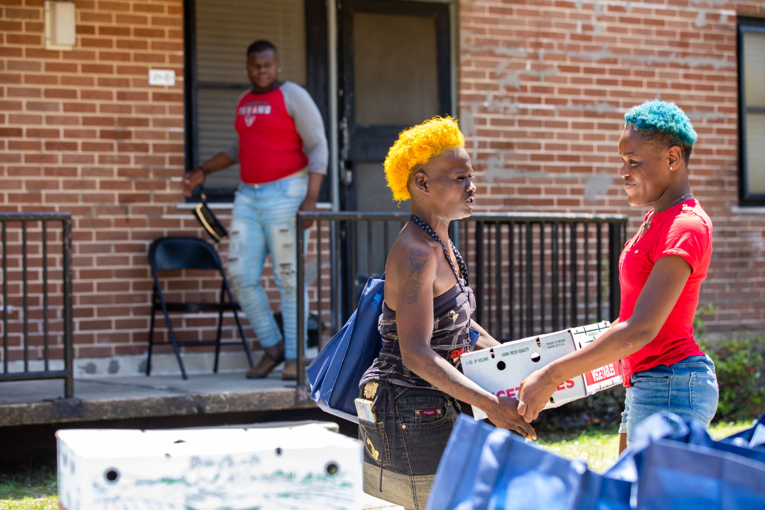 Volunteers carry boxes of fresh produce.