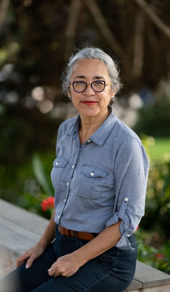 portrait of Cristina Rivera Garza sitting on bench outside