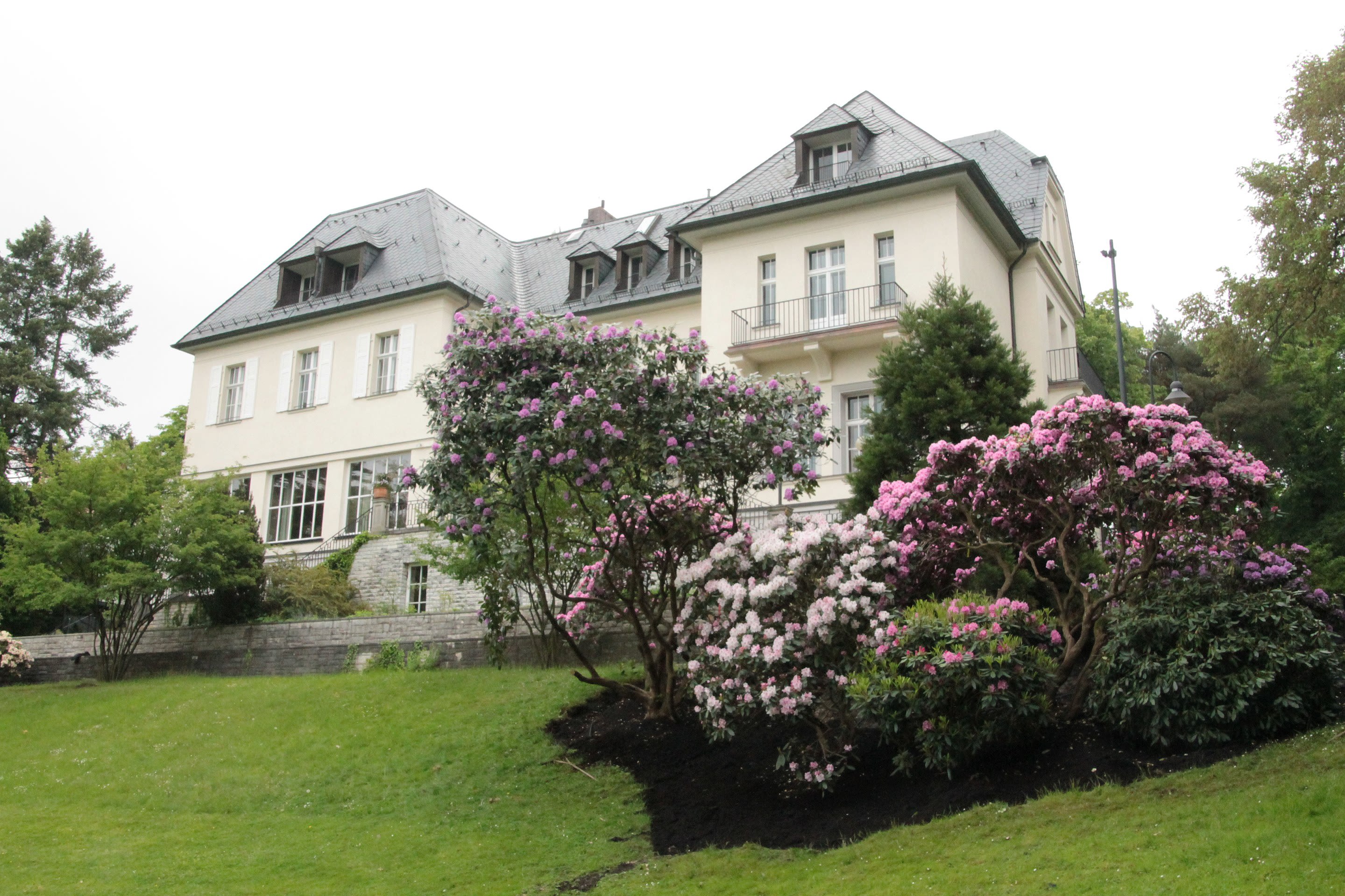 Backyard of The American Academy in Berlin with flowering trees and rolling green lawn