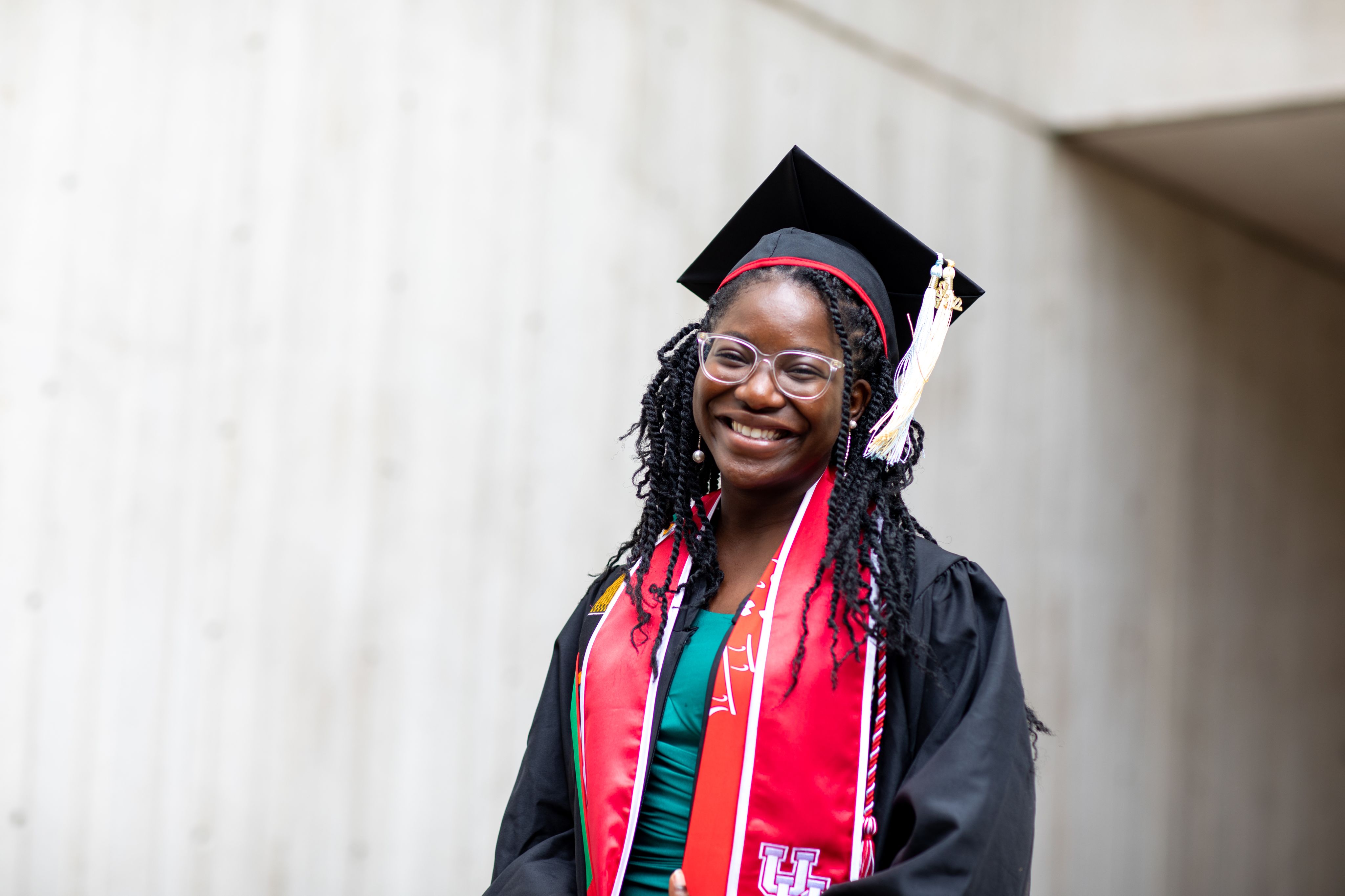 Queen Epomba poses in graduation regalia for photos.