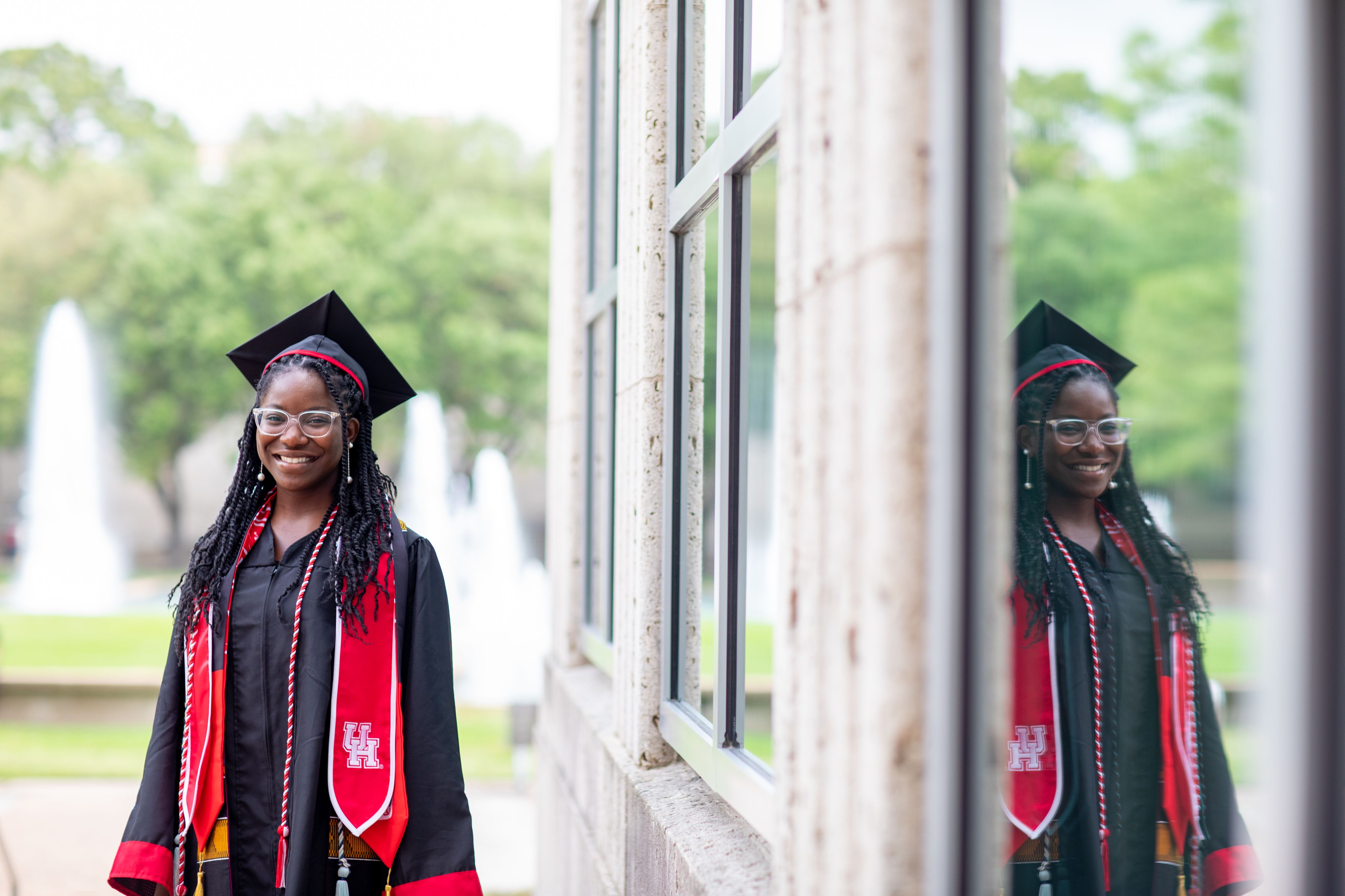 Queen Epomba poses in graduation regalia for photos.
