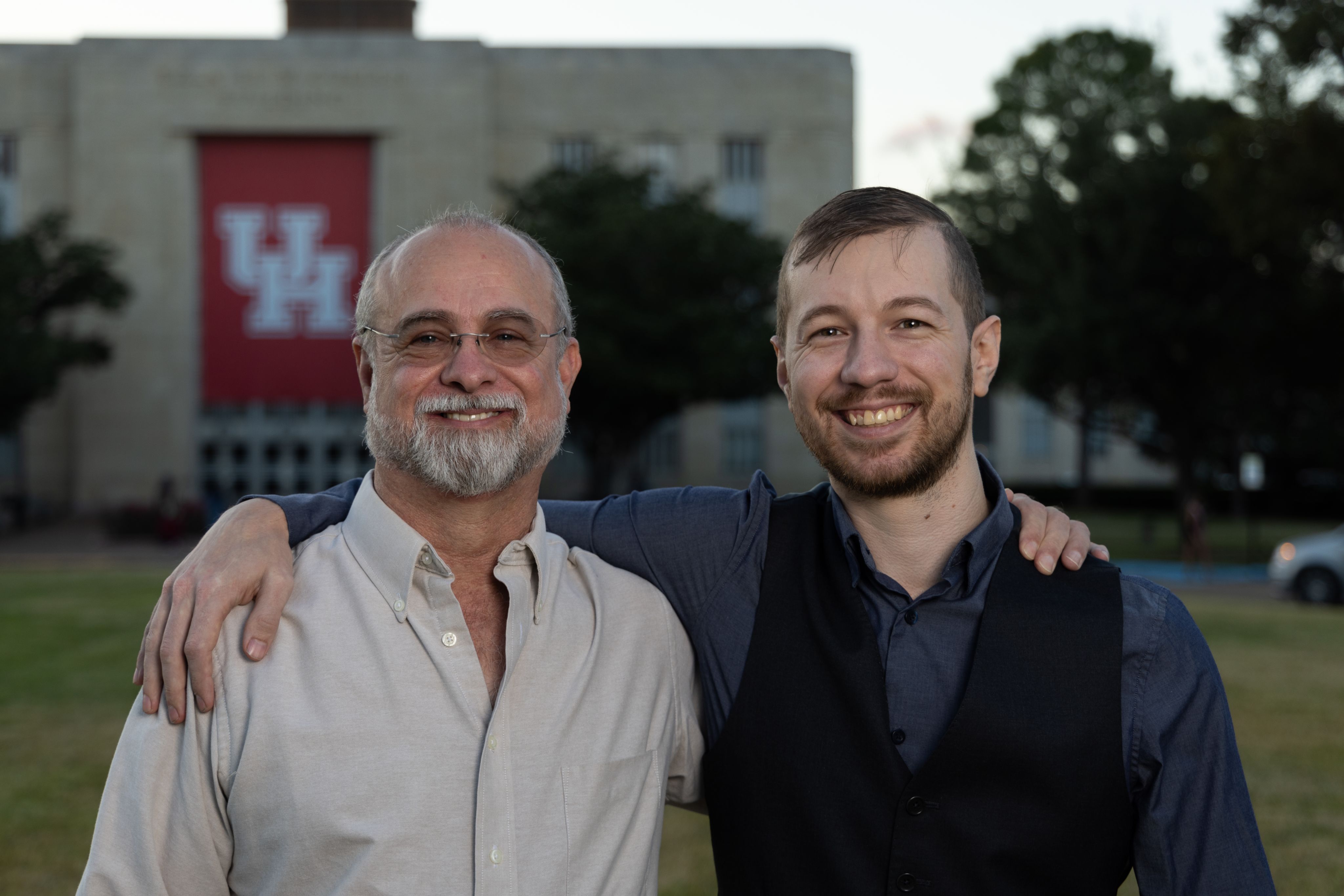 A portrait of Levi and Ross smiling in front of the E Cullen Building