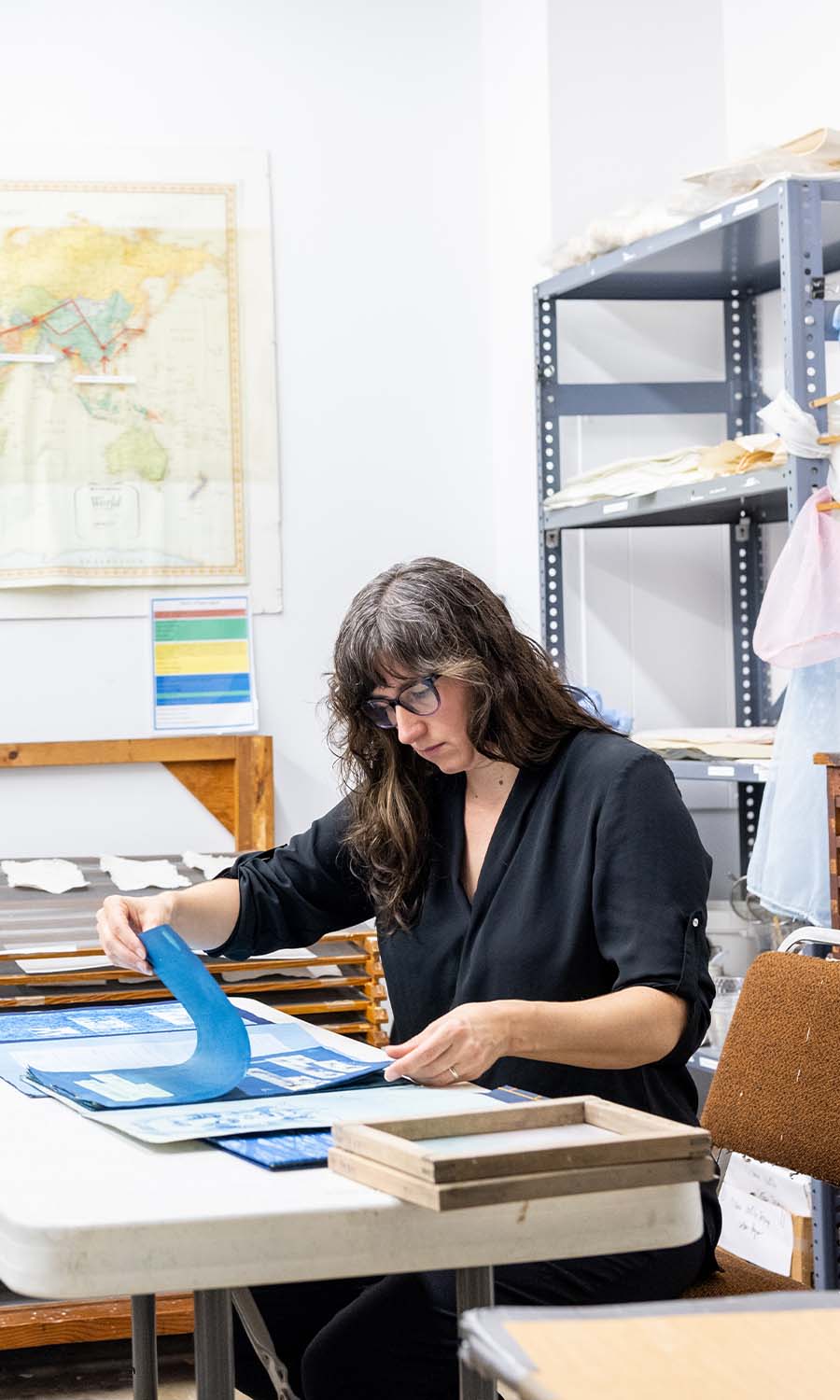 Anderson-Staley flips through one of her books from her “Raw Materials in Peace and War” exhibition.