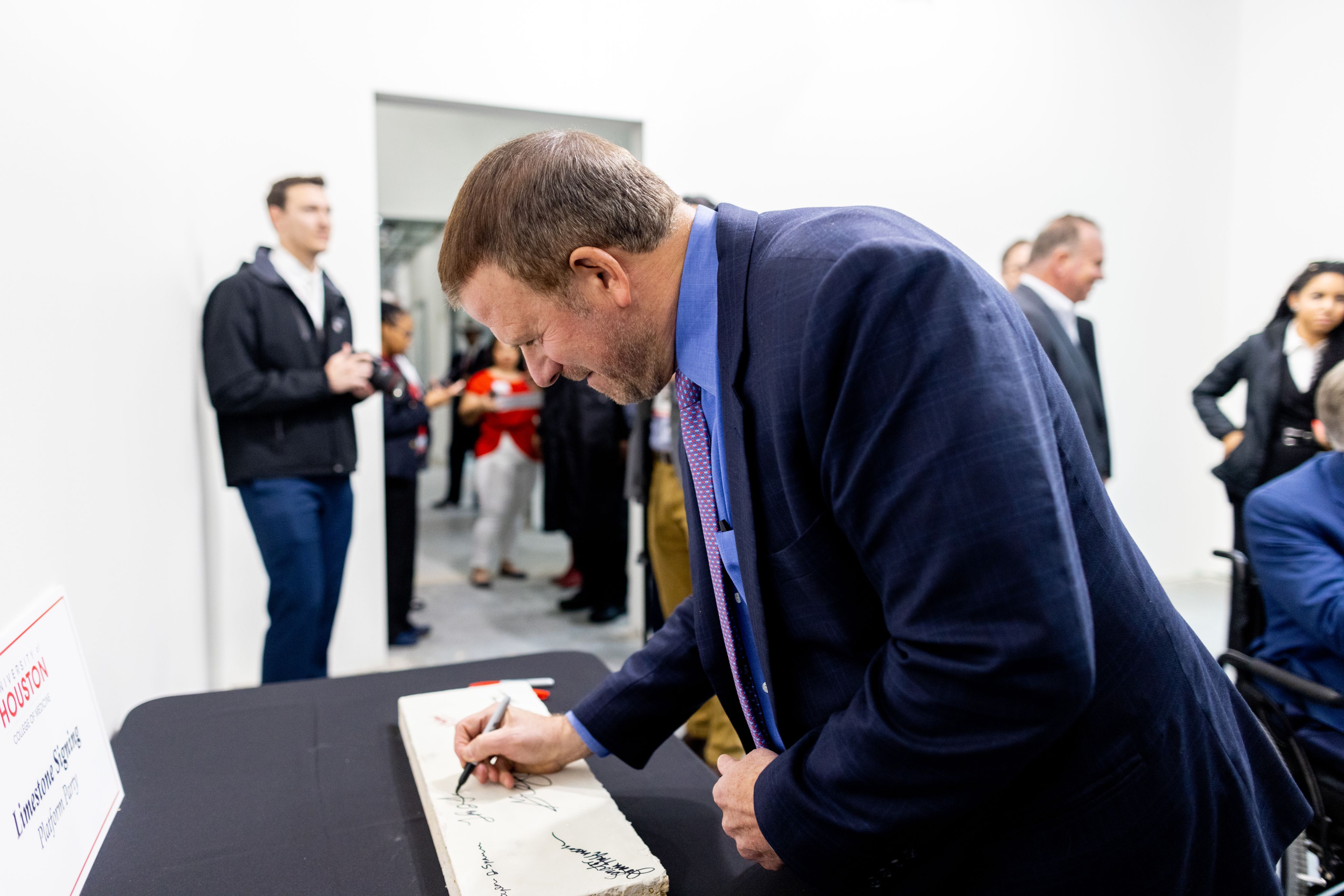 Tilman Fertitta signs a piece of limestone at an exclusive preview of the new College of Medicine building
