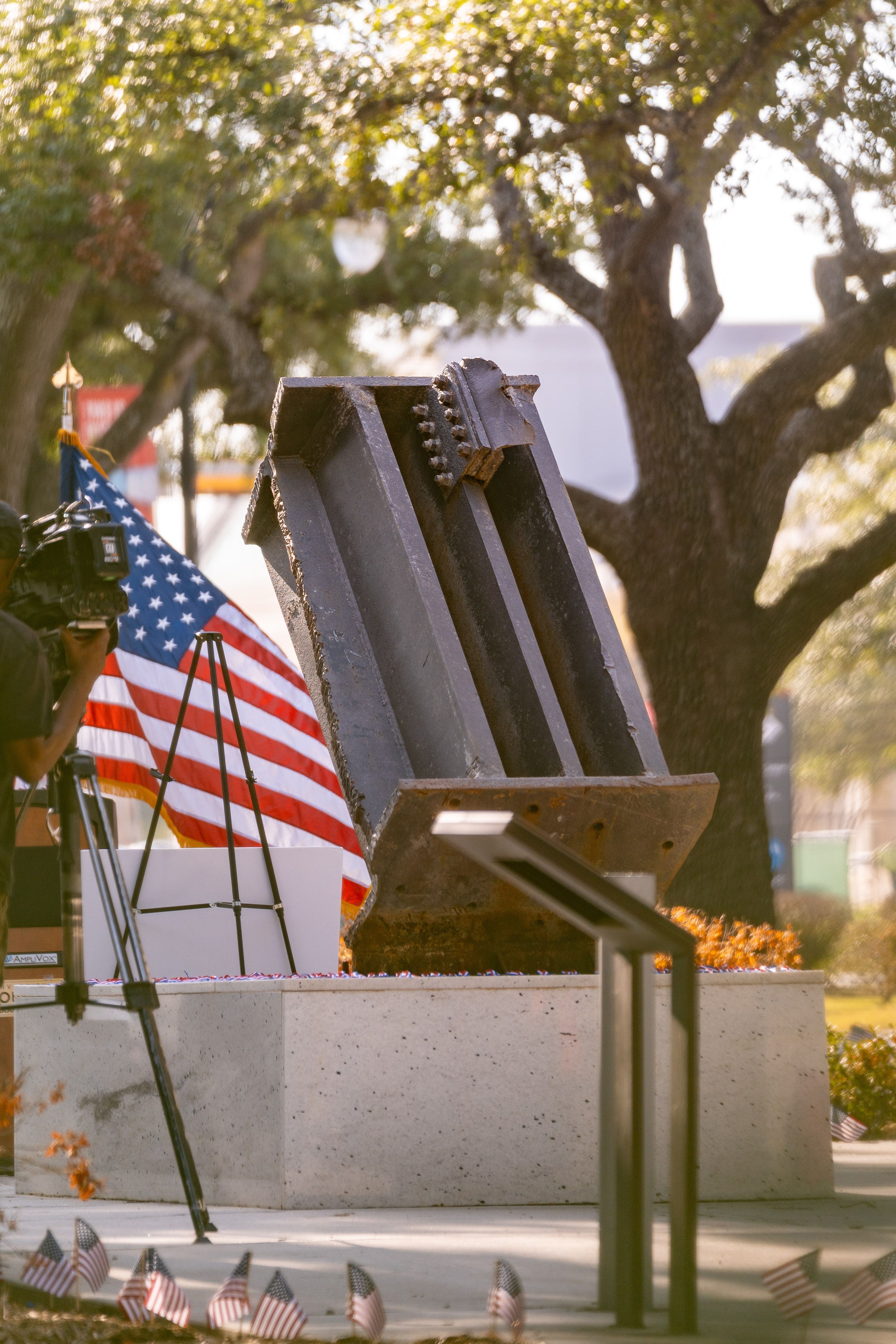 photo of an American flag in the background and steel beam from the World Trade Center on the UH campus.