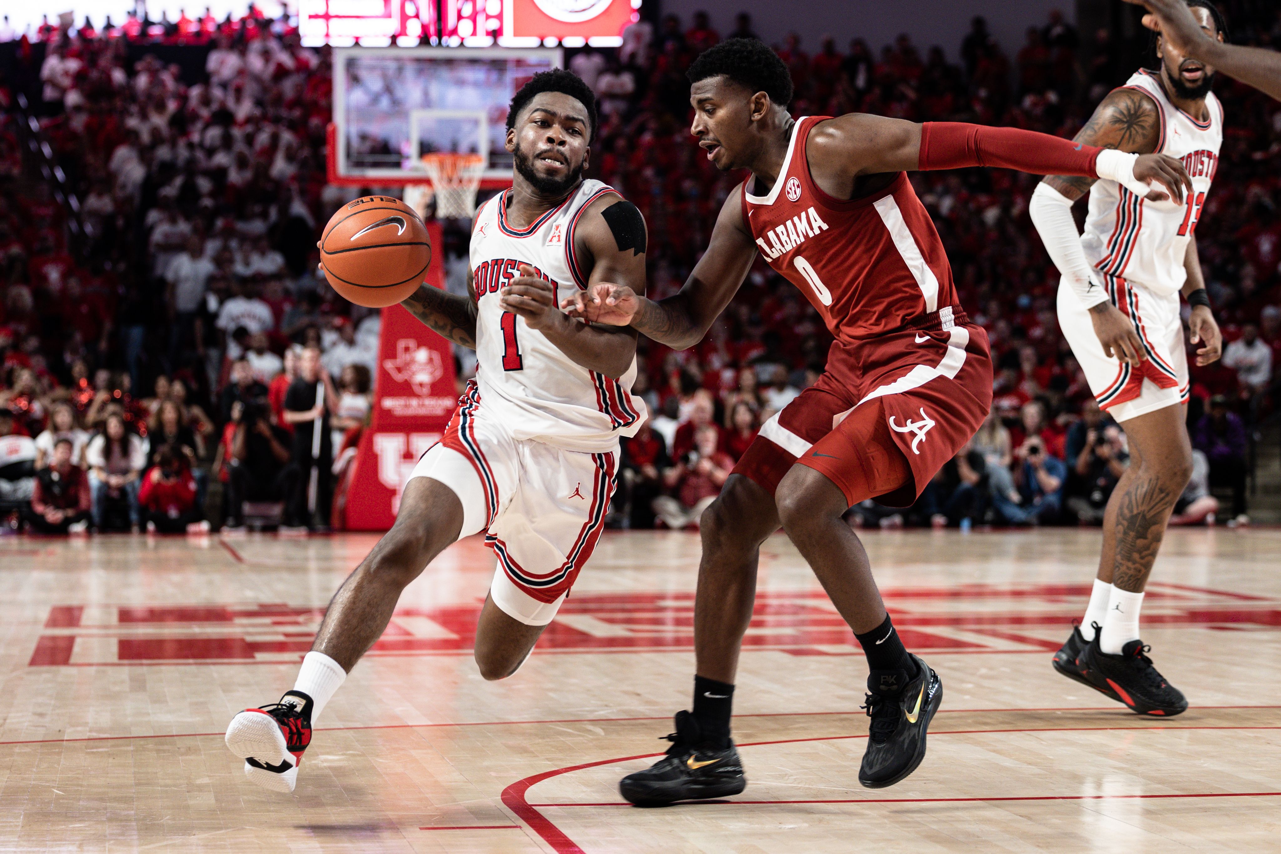 Jamal Shead drives towards basket next to an opposing player.