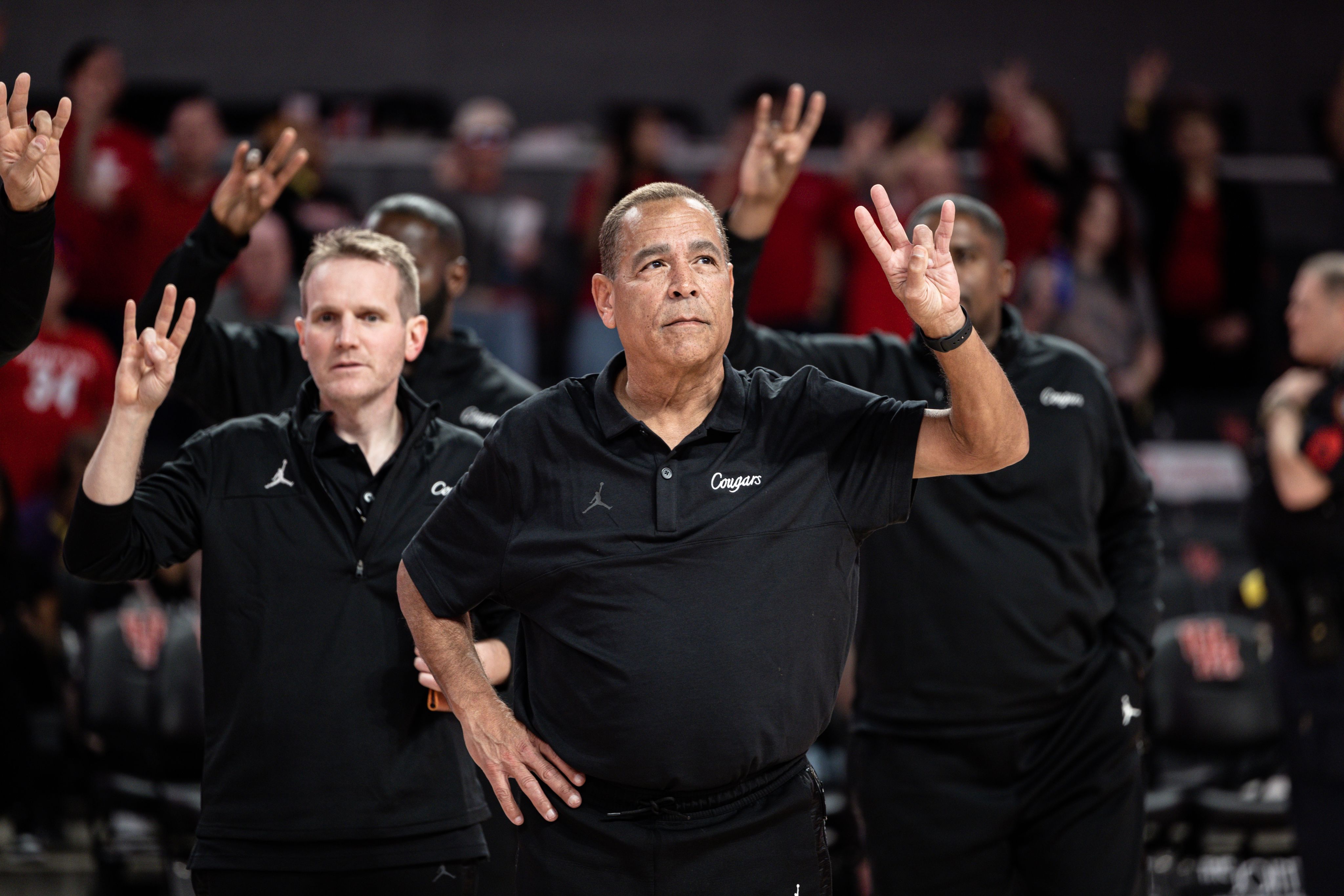 Coach Sampson makes a cougar paw gesture with his hand.