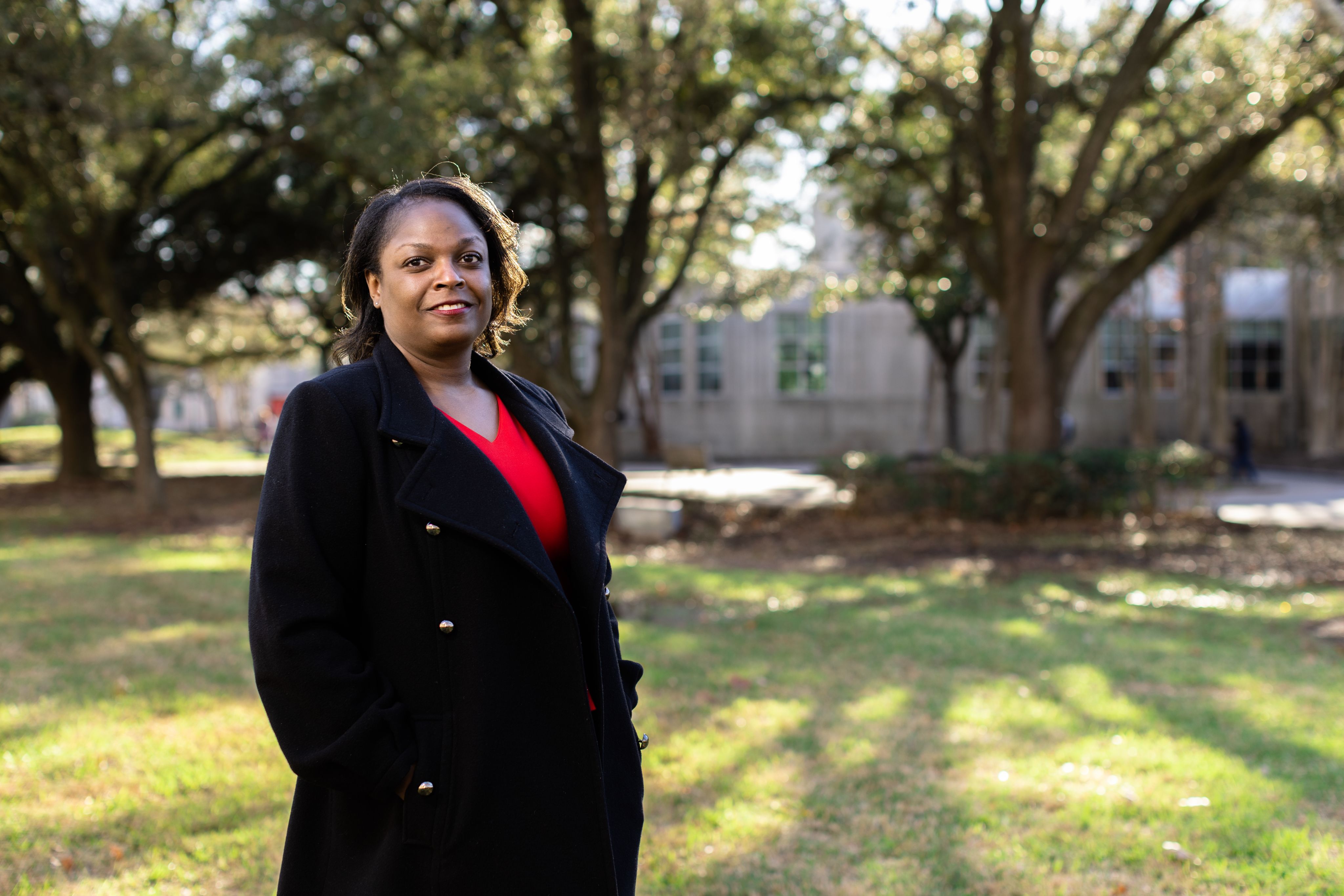 African American female wearing black jacket and red shirt