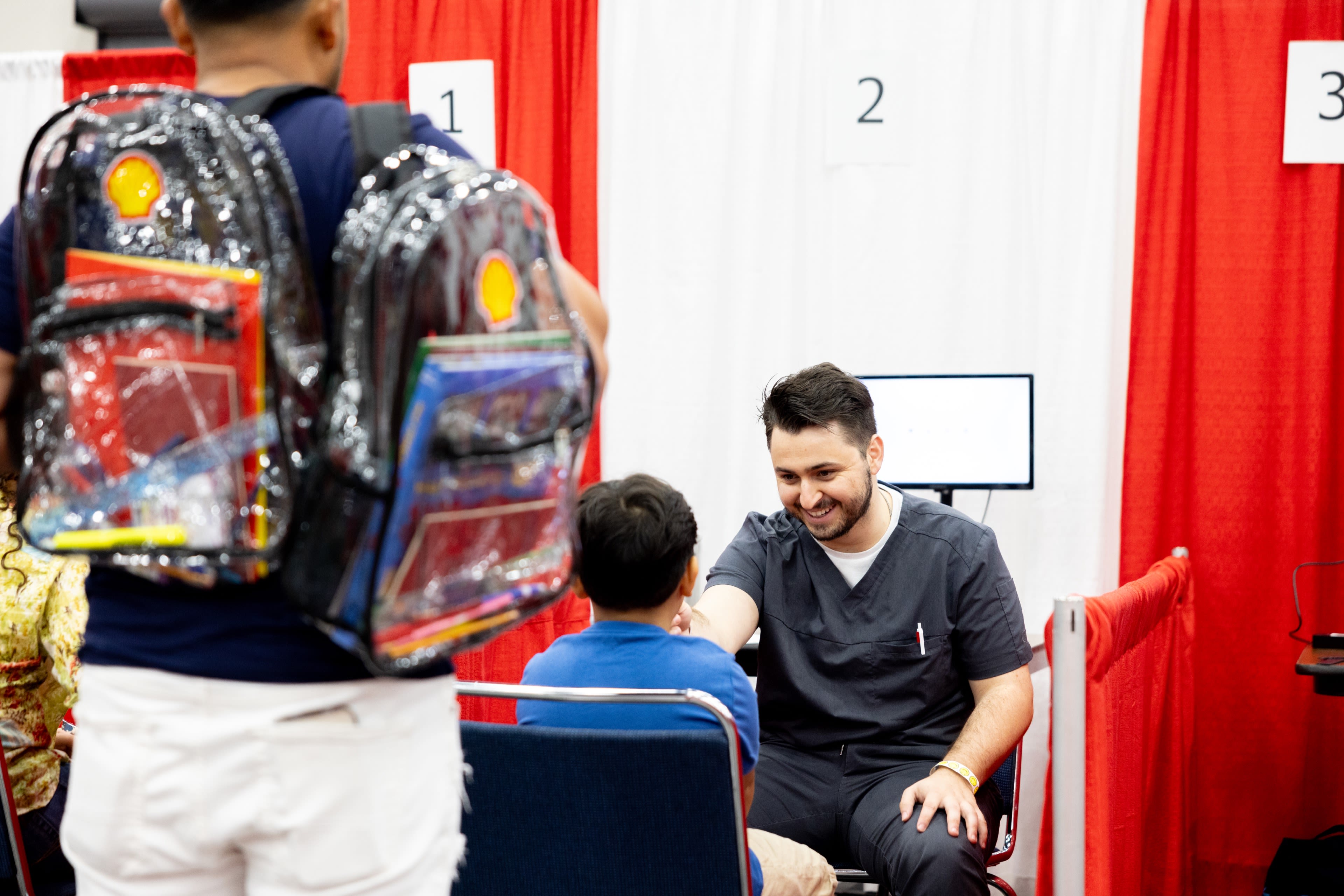 A UH volunteer provides a vision check for a student