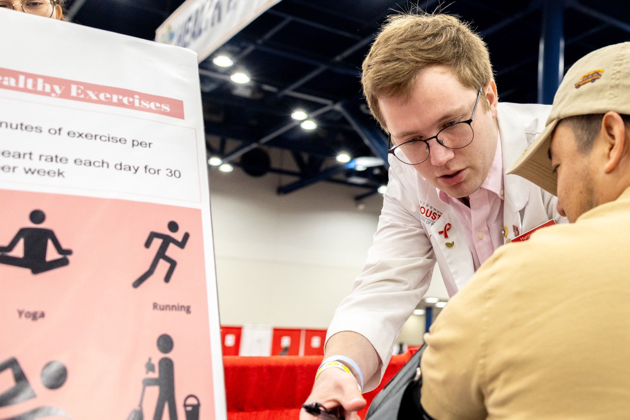 Hunter Adam, a third-year pharmacy student, provides a blood pressure screening at the Mayor's Back to School Fest.