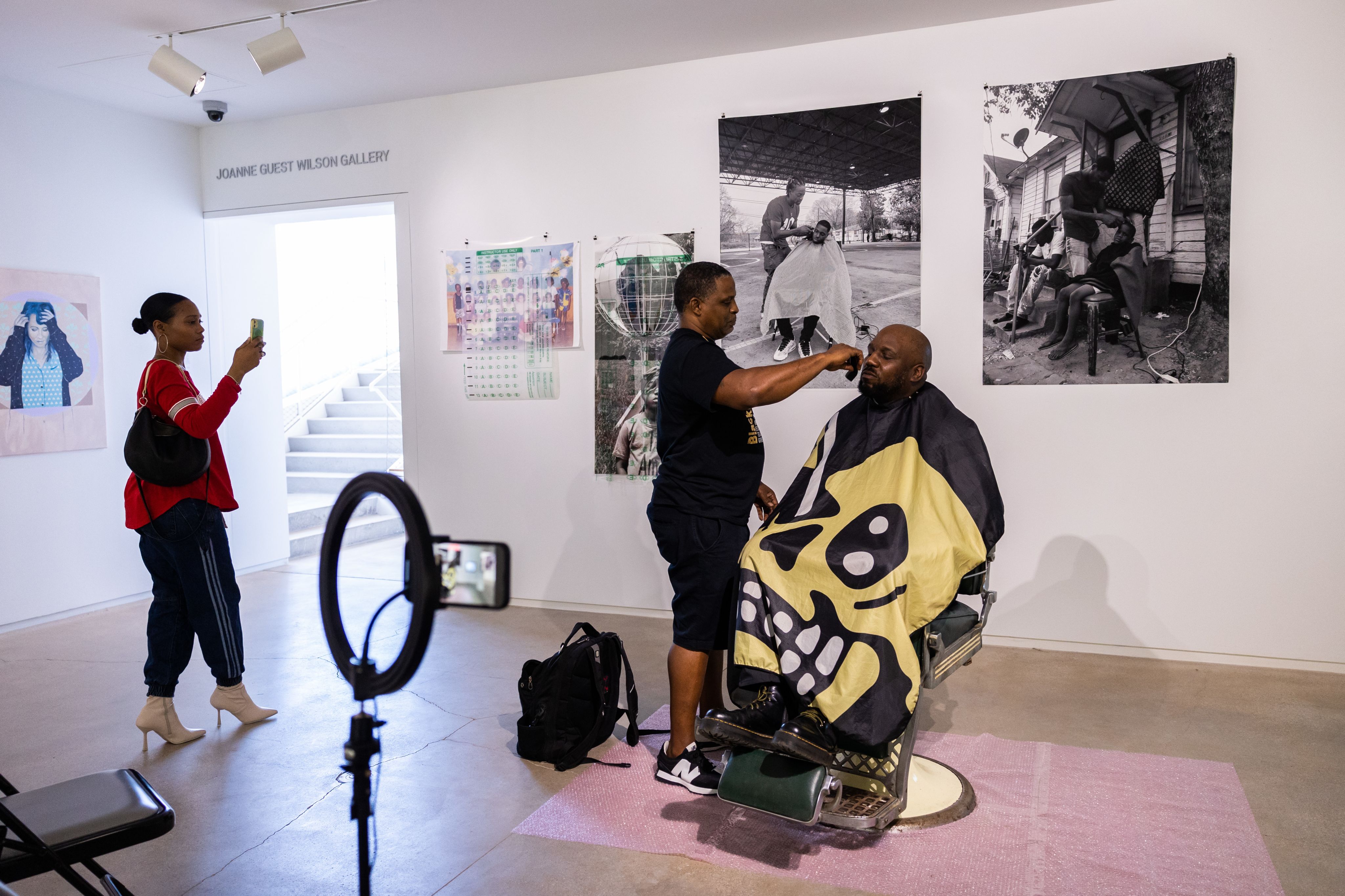Brian Ellison gets a haircut in a barber chair at his senior thesis at blaffer art museum