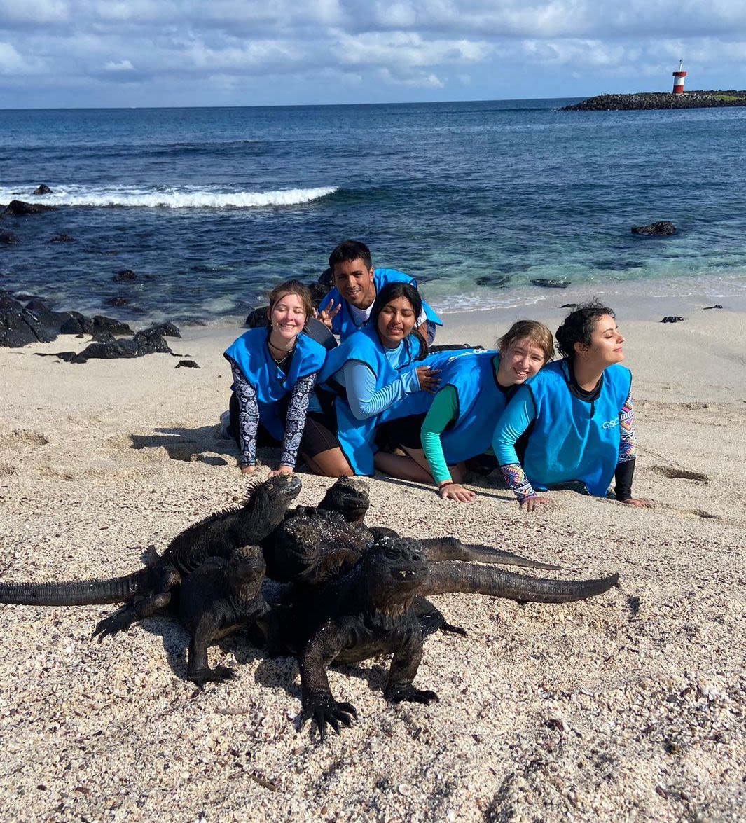 University of Houston students in the sand with lava lizards on the Galapagos Islands