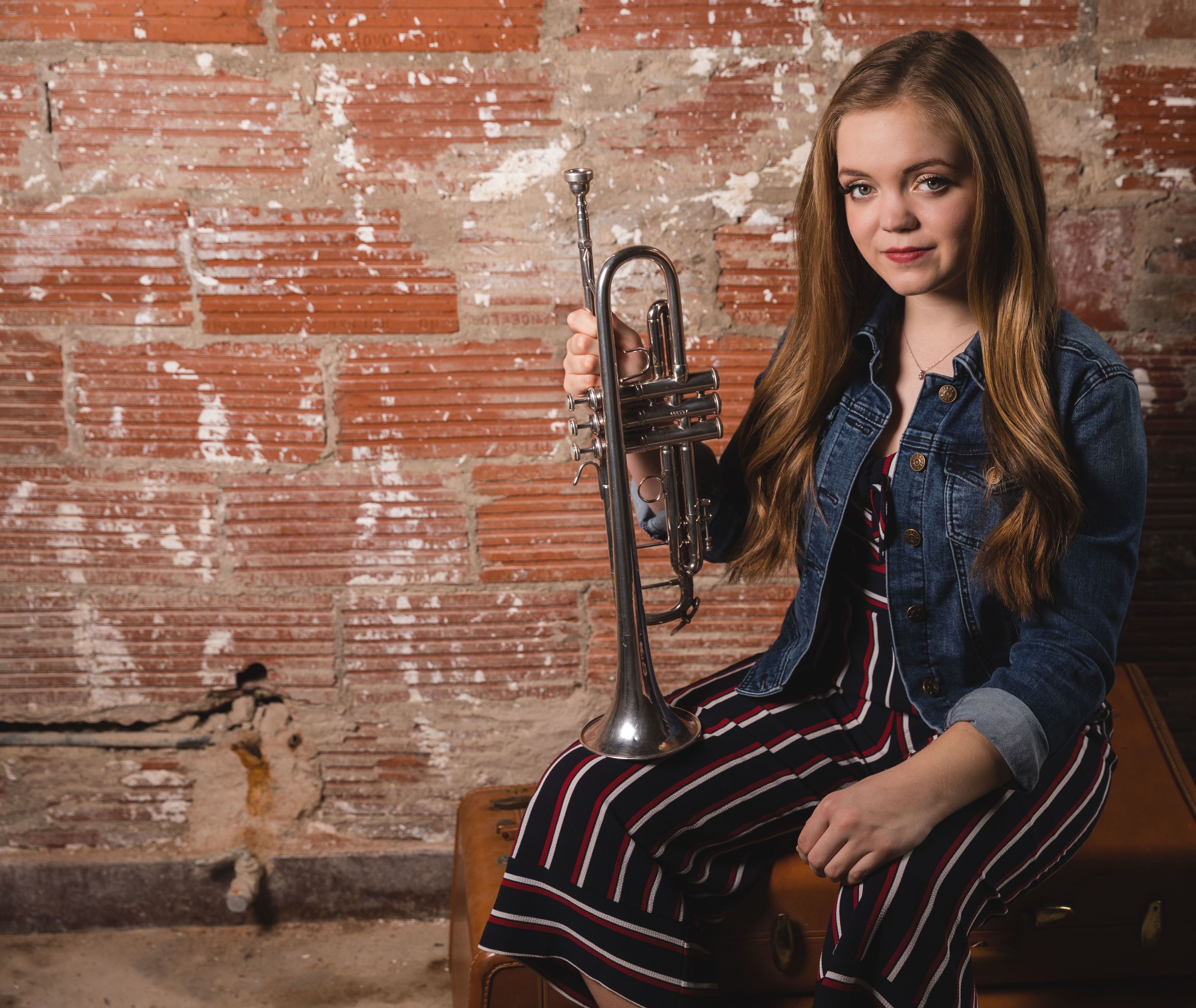 Sara Grace holding trumpet, looking at camera