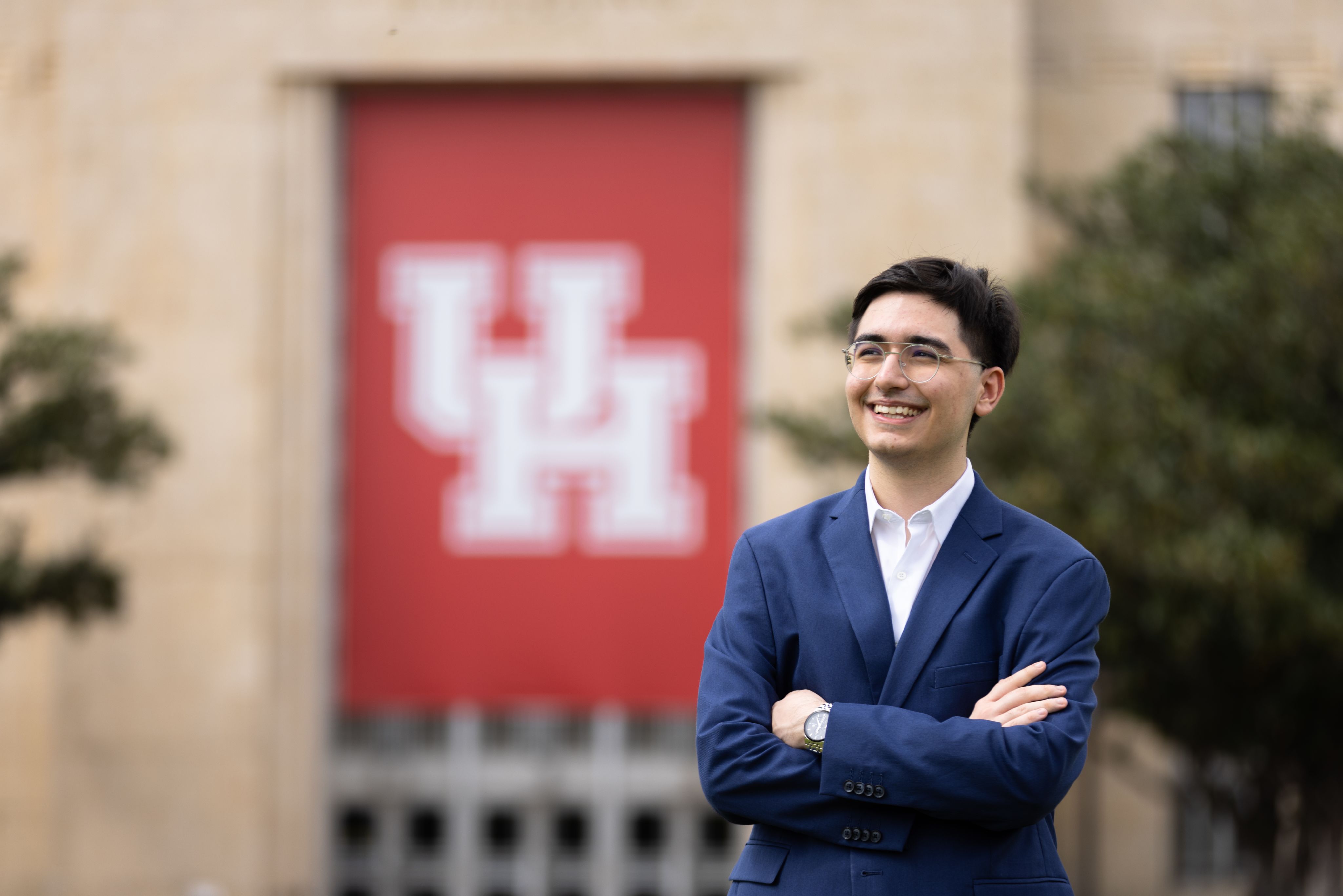 Mielad Ziaee smiling with arms crossed in front of Ezekiel W. Cullen building.