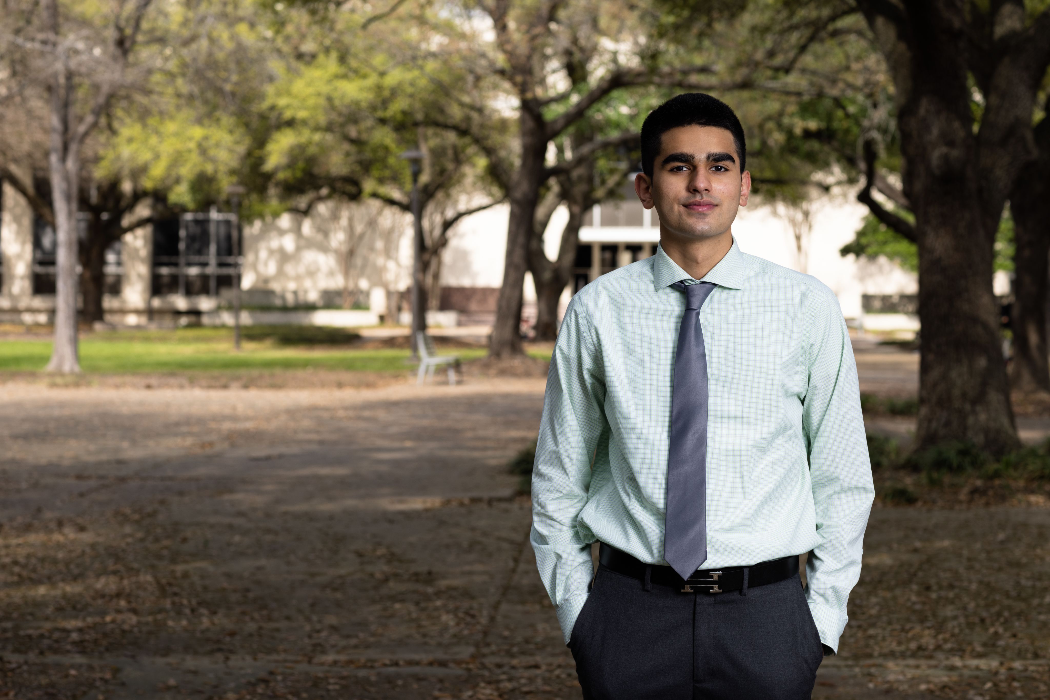 Hassaan Memon standing in front of trees for portrait.