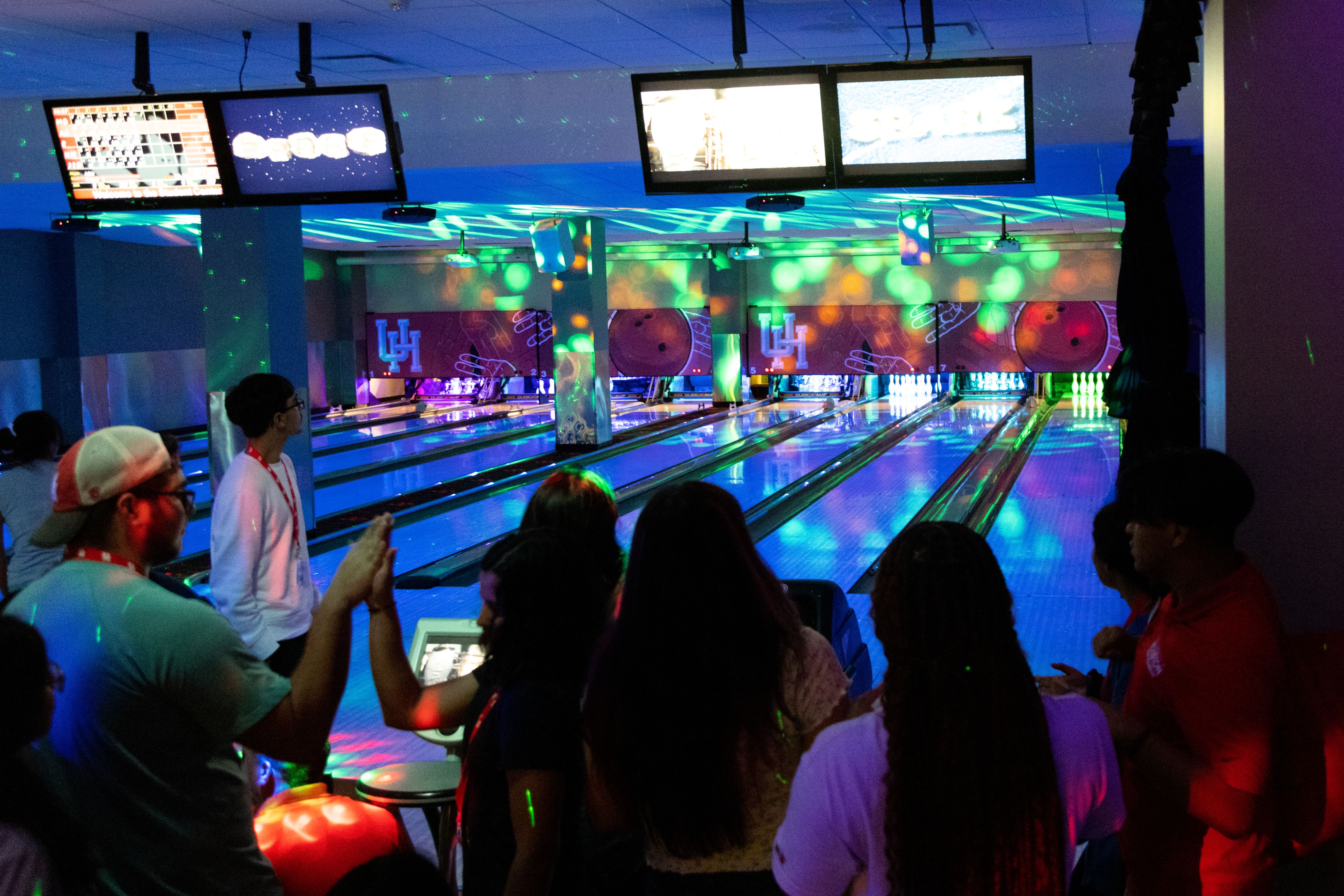 Bowling alley in the Student Centers Games Room lit up in neon colors as incoming students enjoy time together.