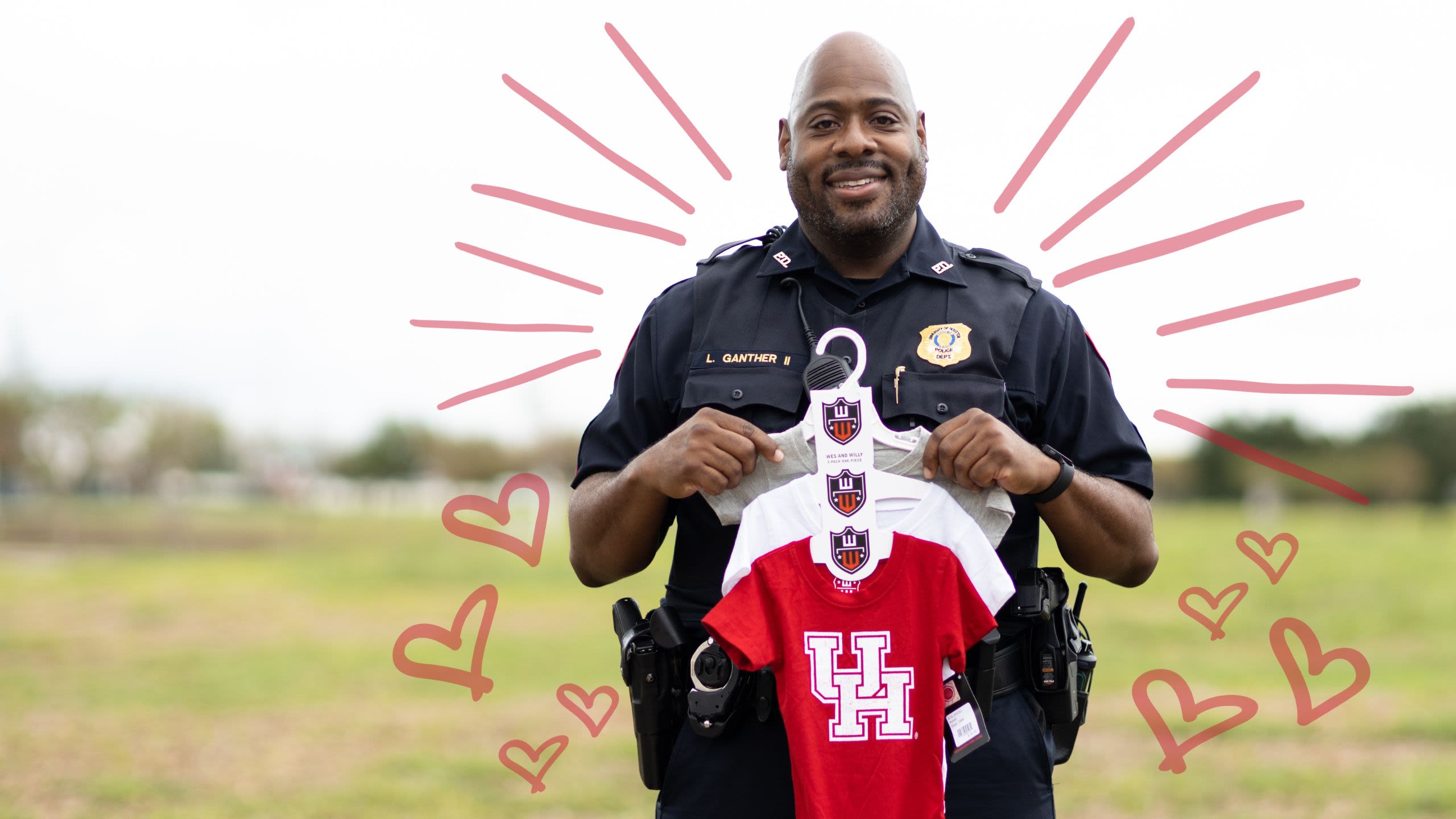 Sgt. Ganther in uniform holding a three-pack of UH-branded baby onesies