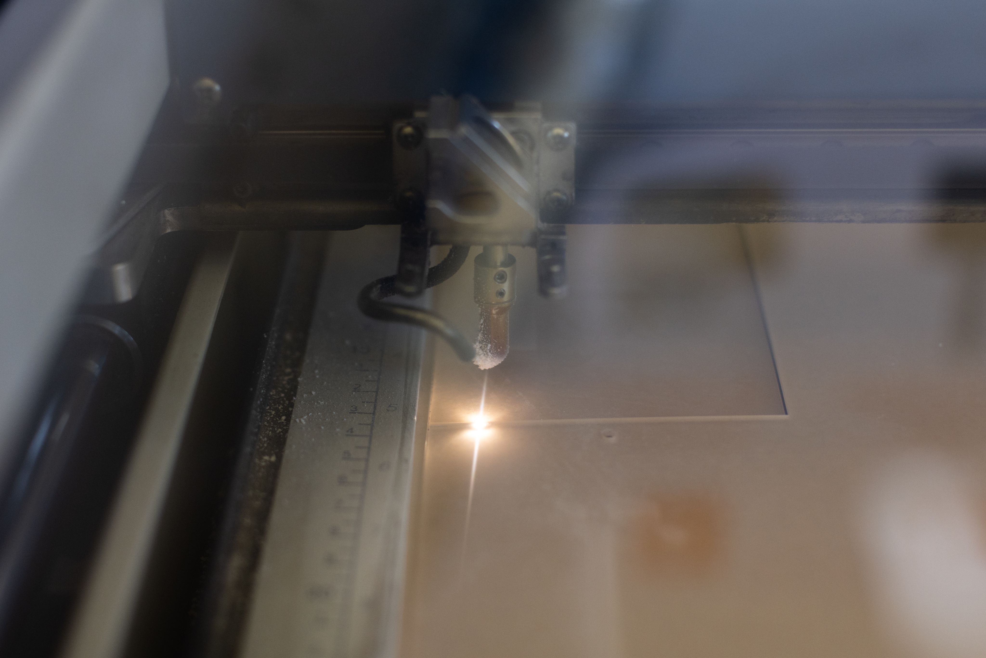 Photo of laser cutter cutting out a square.