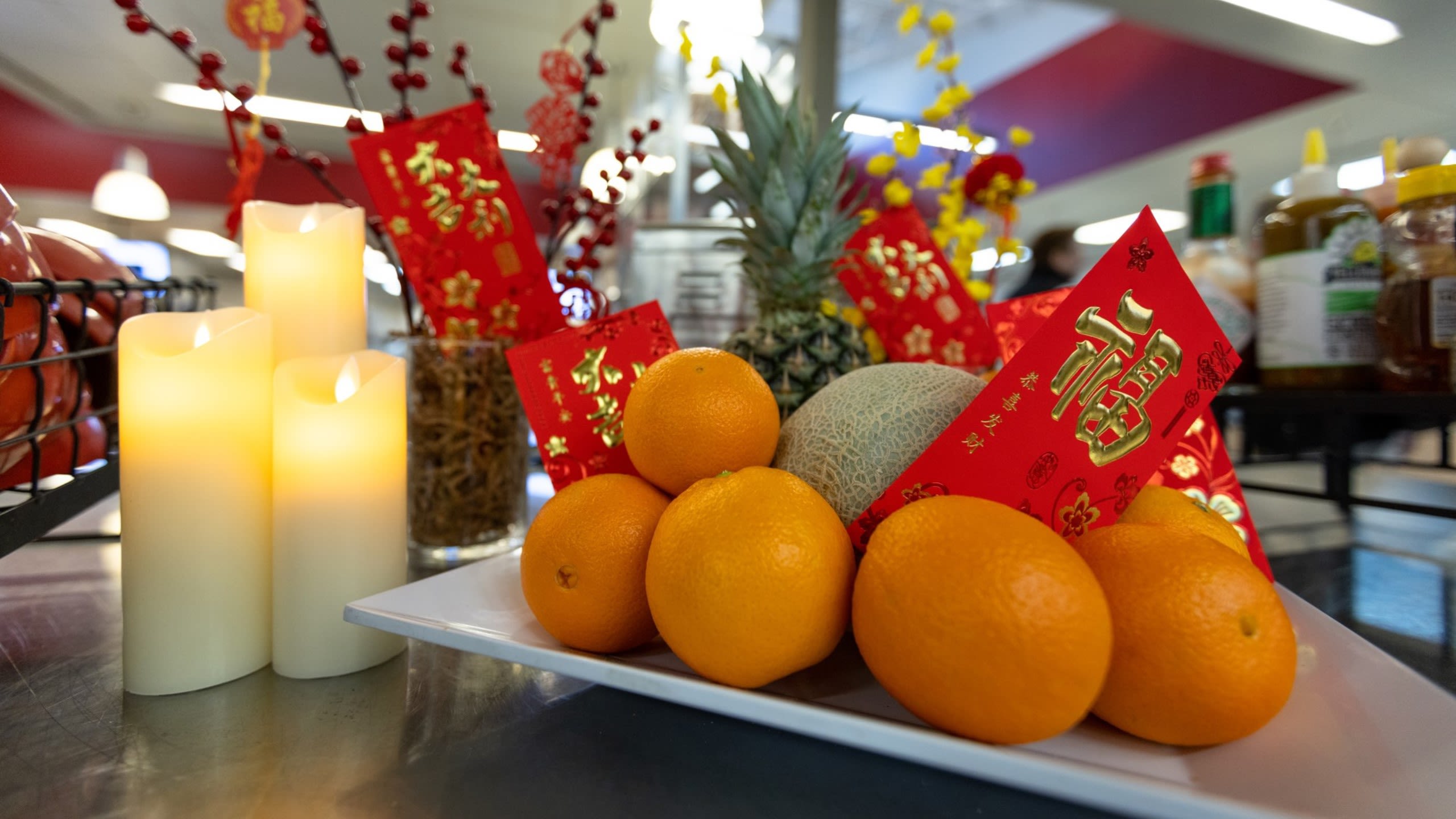 Lunar New Year décor of candles, red envelopes, and fresh oranges at Cougar Woods Dining Commons