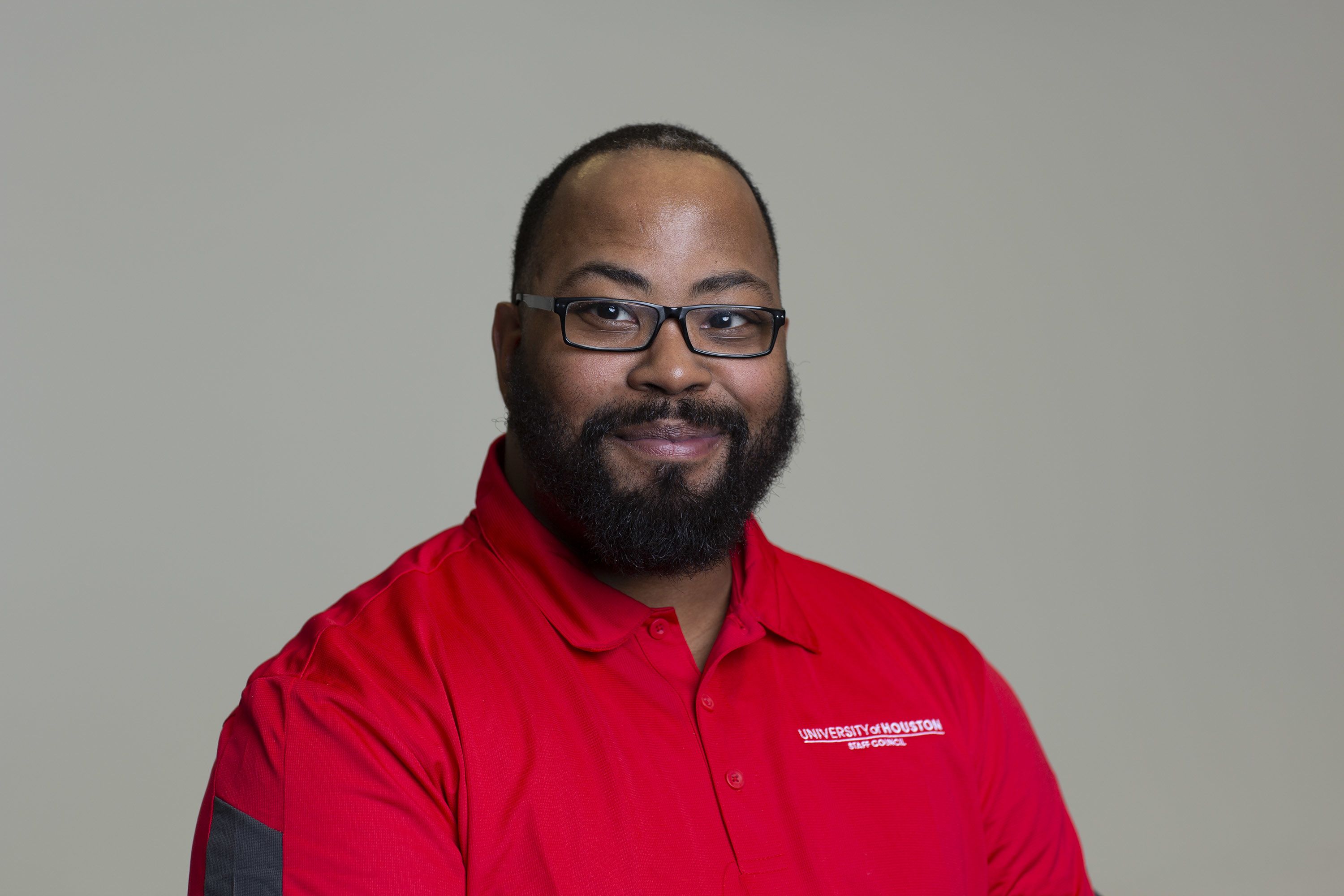 Portrait of Karl Hearne wearing a UH Staff Council red polo.