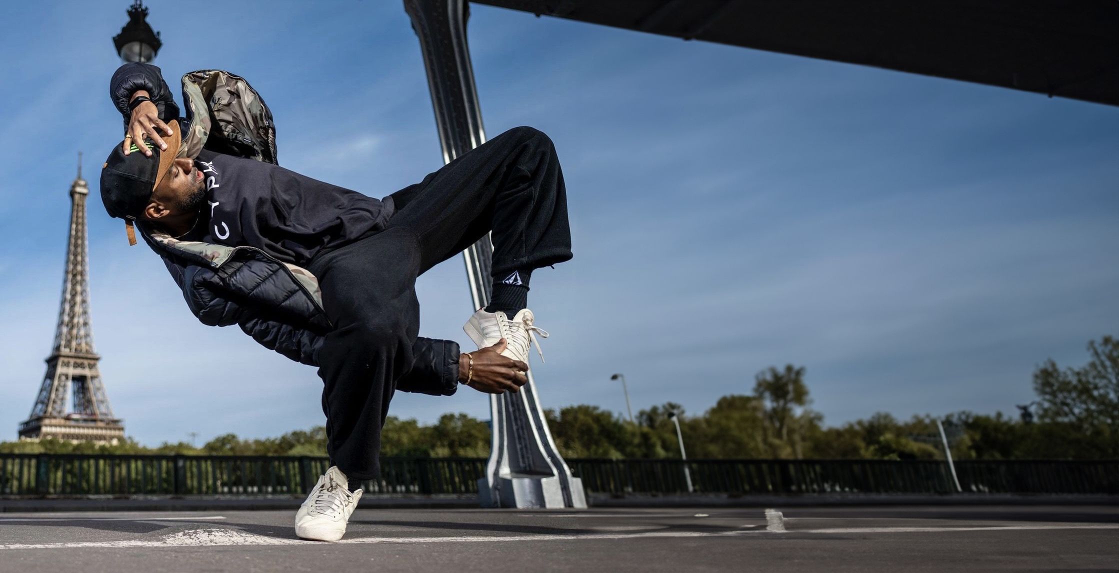 Photo of Jeffrey Louis breakdancing in front of the Eiffel Tower.