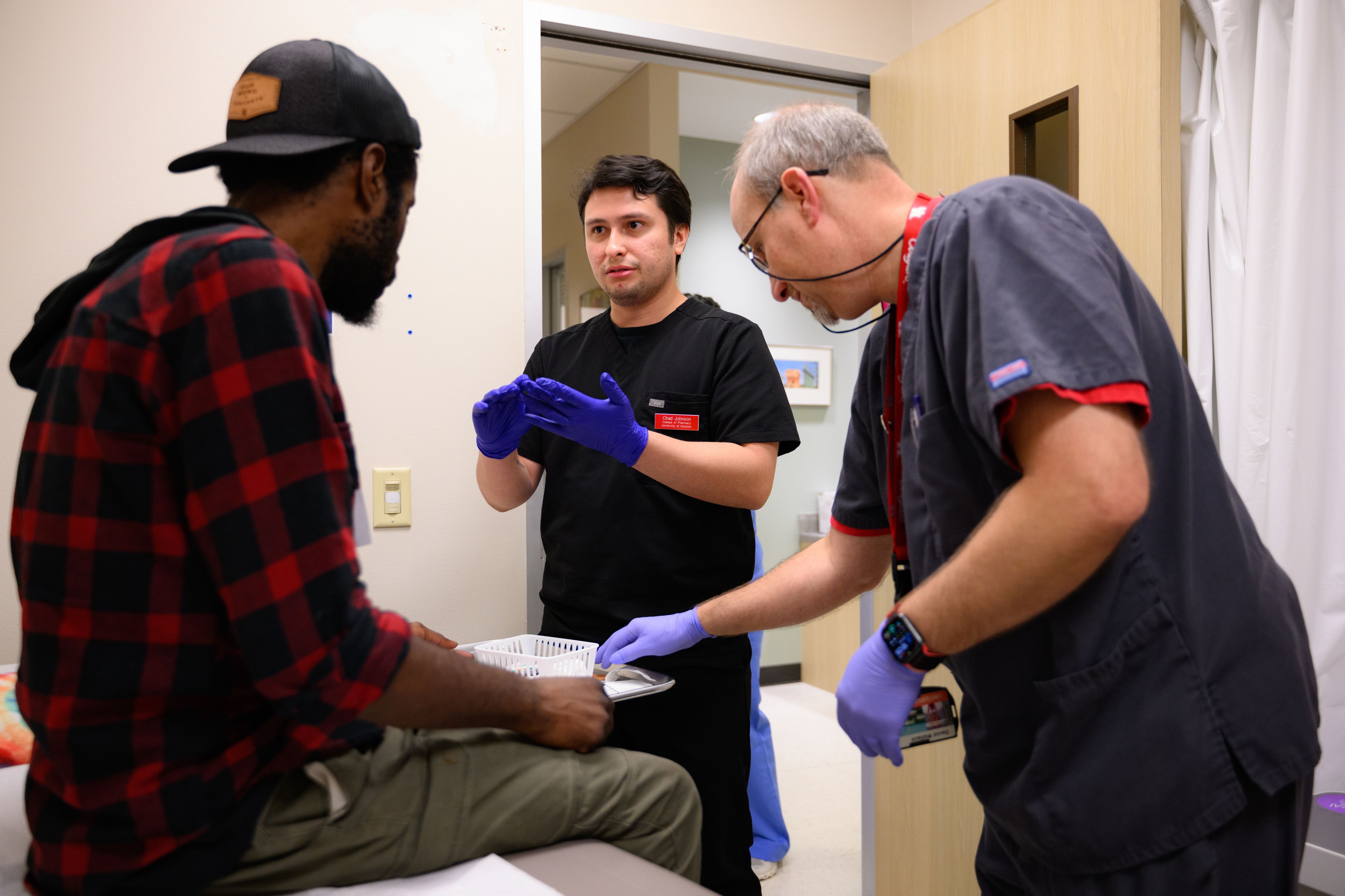 David Wallace and a student visit with a patient