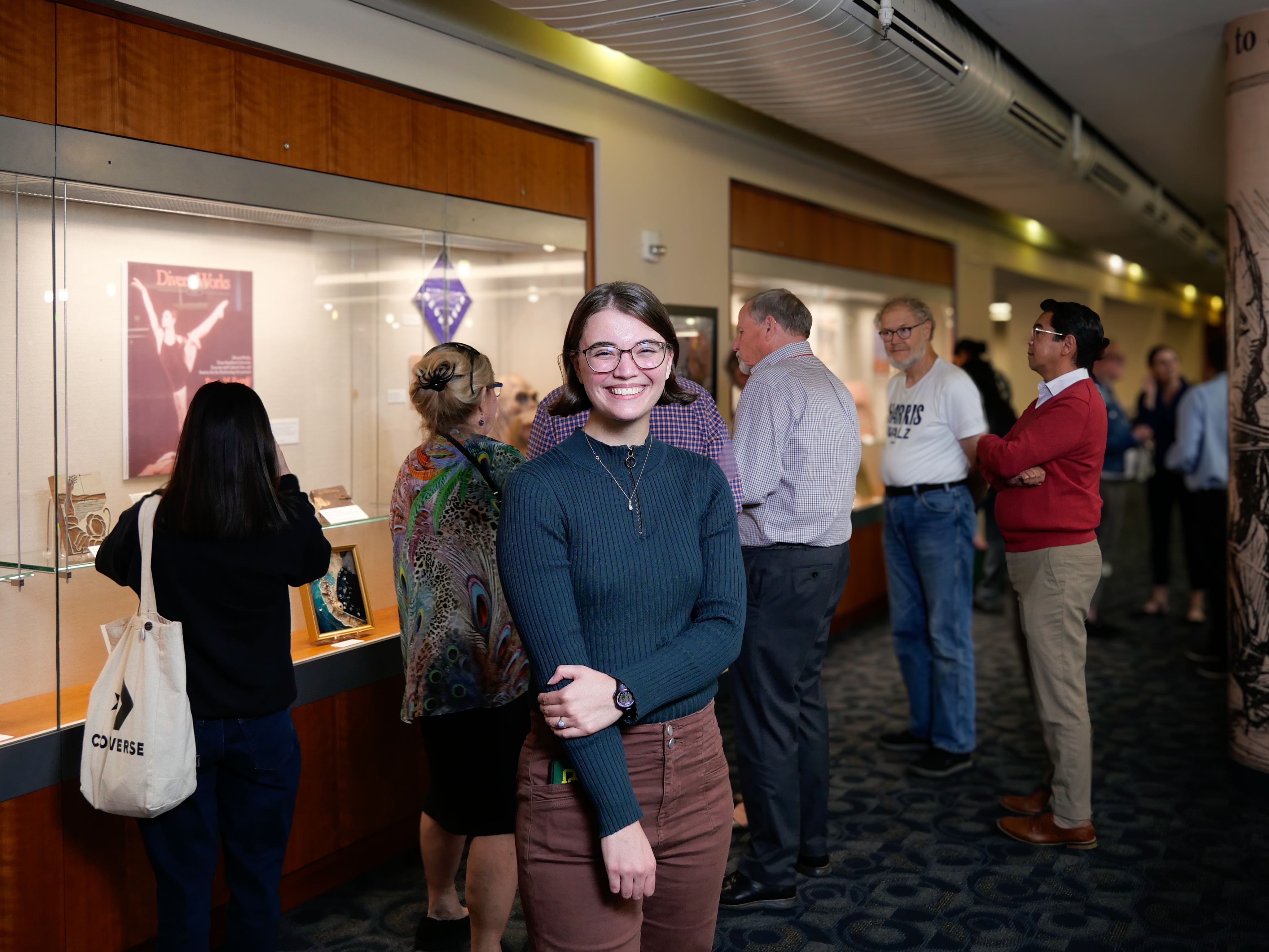 Claire Keck standing in front of her exhibit "Nevertheless She Persisted" 