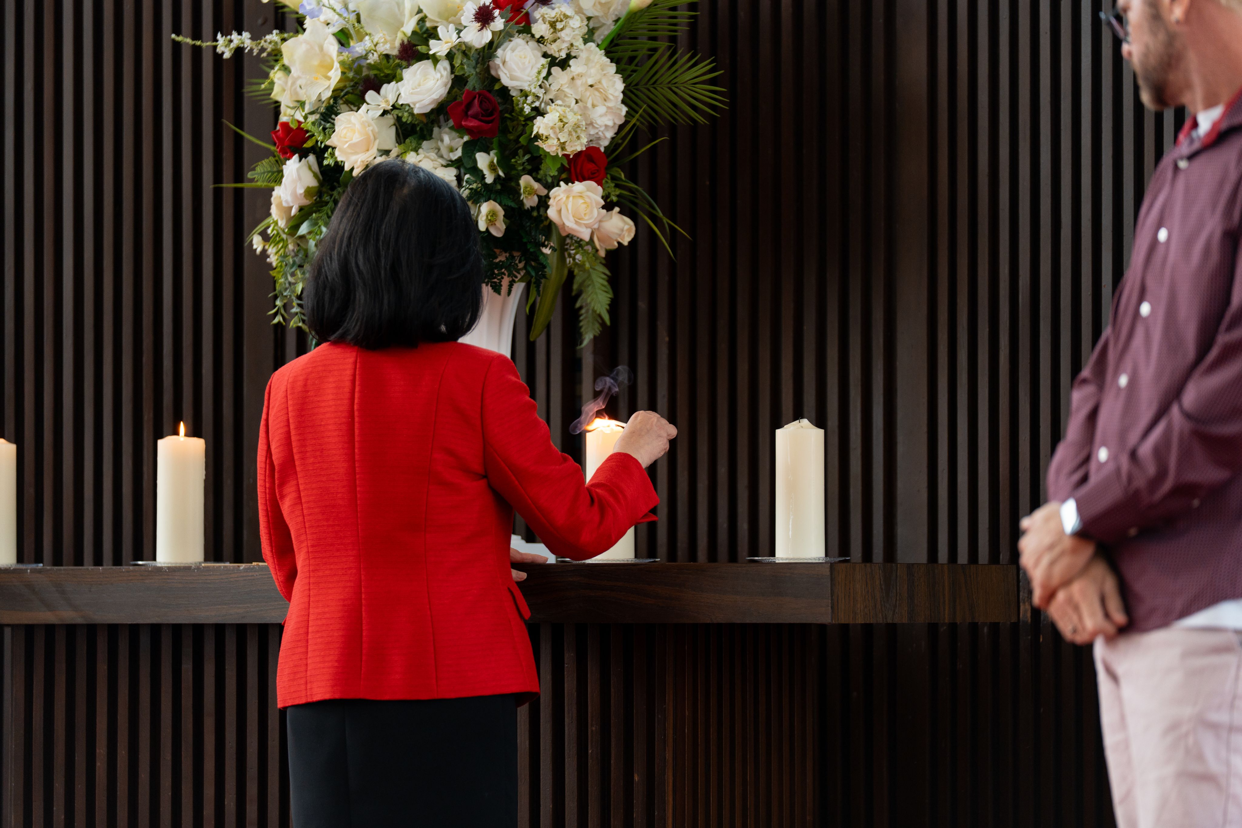 Agnes L. DeFranco, representing the UH Alumni Association, lighting a candle in. A.D. Bruce Religion Center.