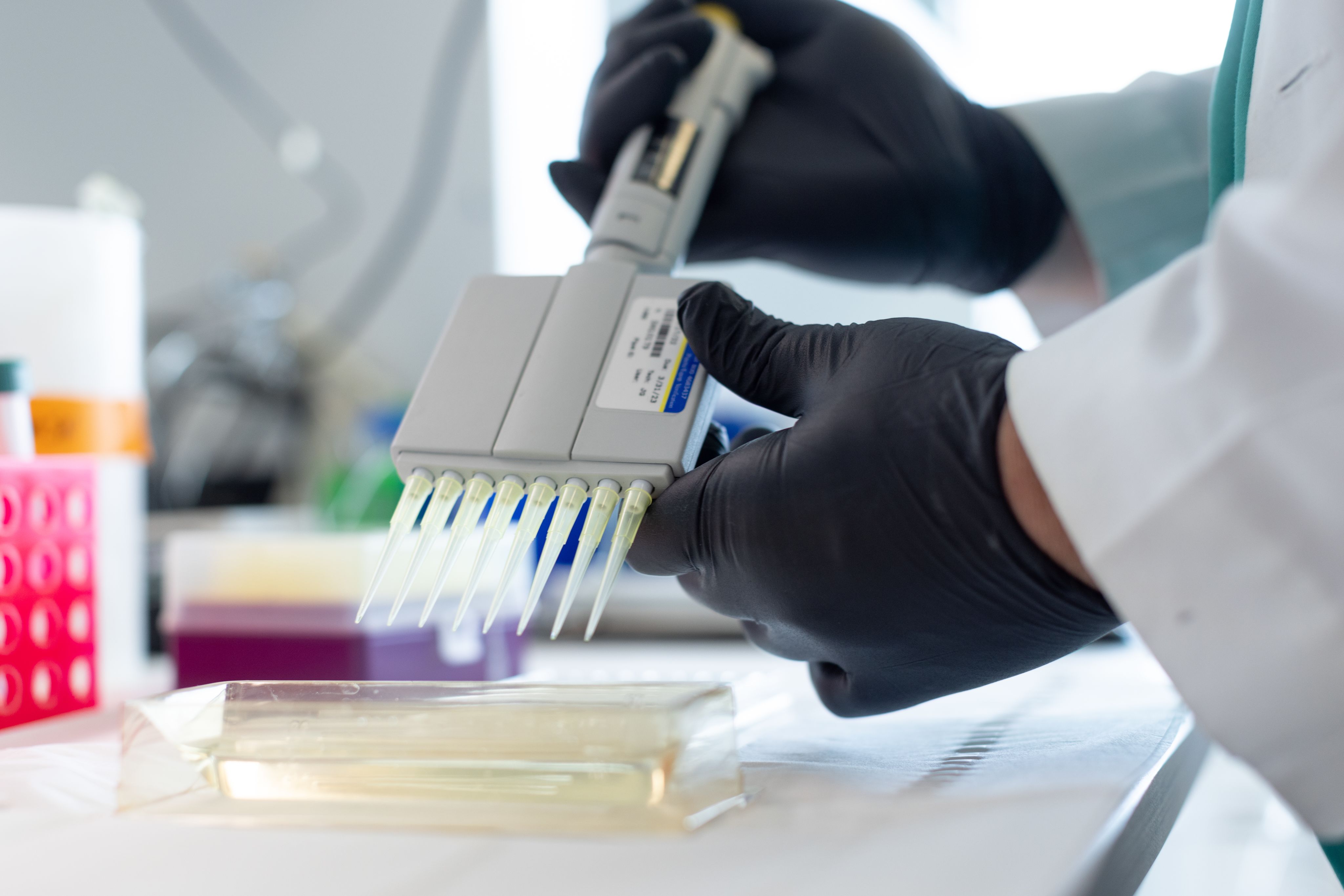A laboratory professional in a lab coat engages with a device, emphasizing scientific research and innovation.