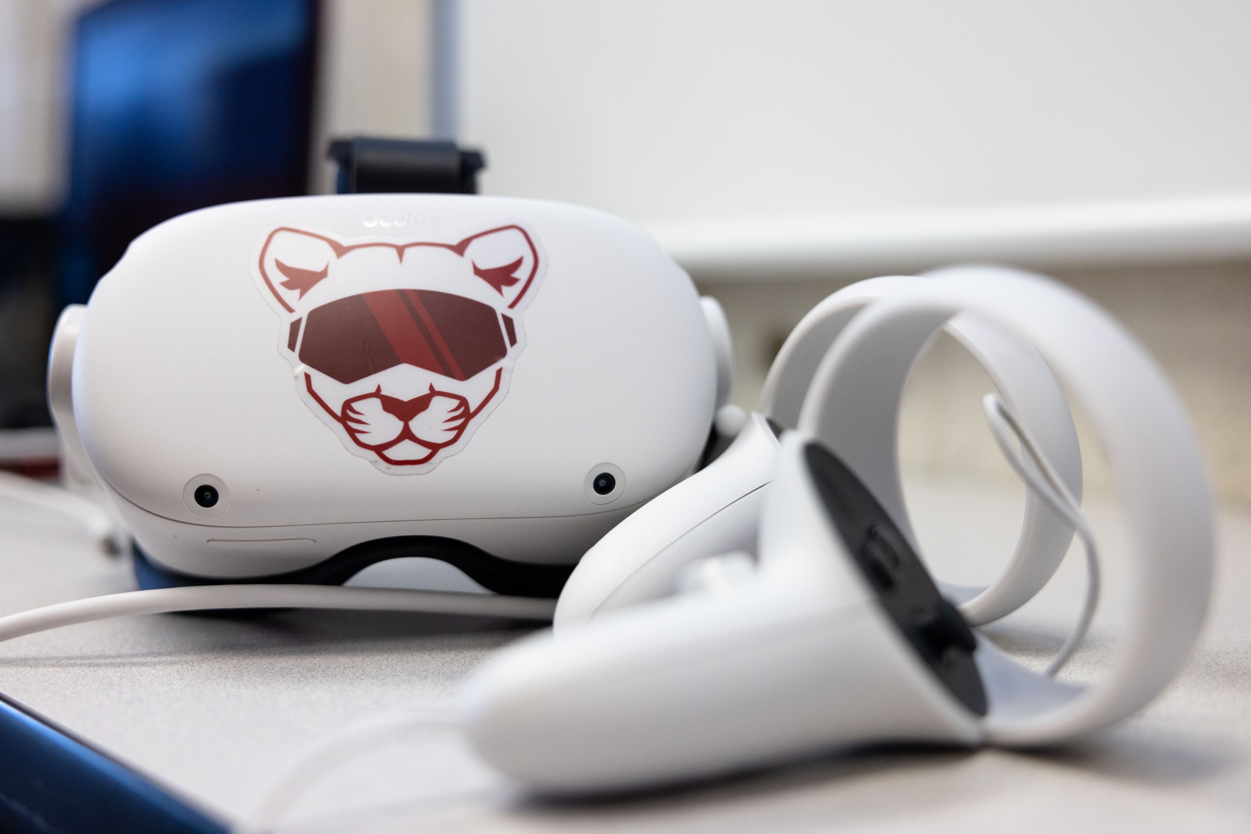 White goggles with illustration of cougar and headphones.
