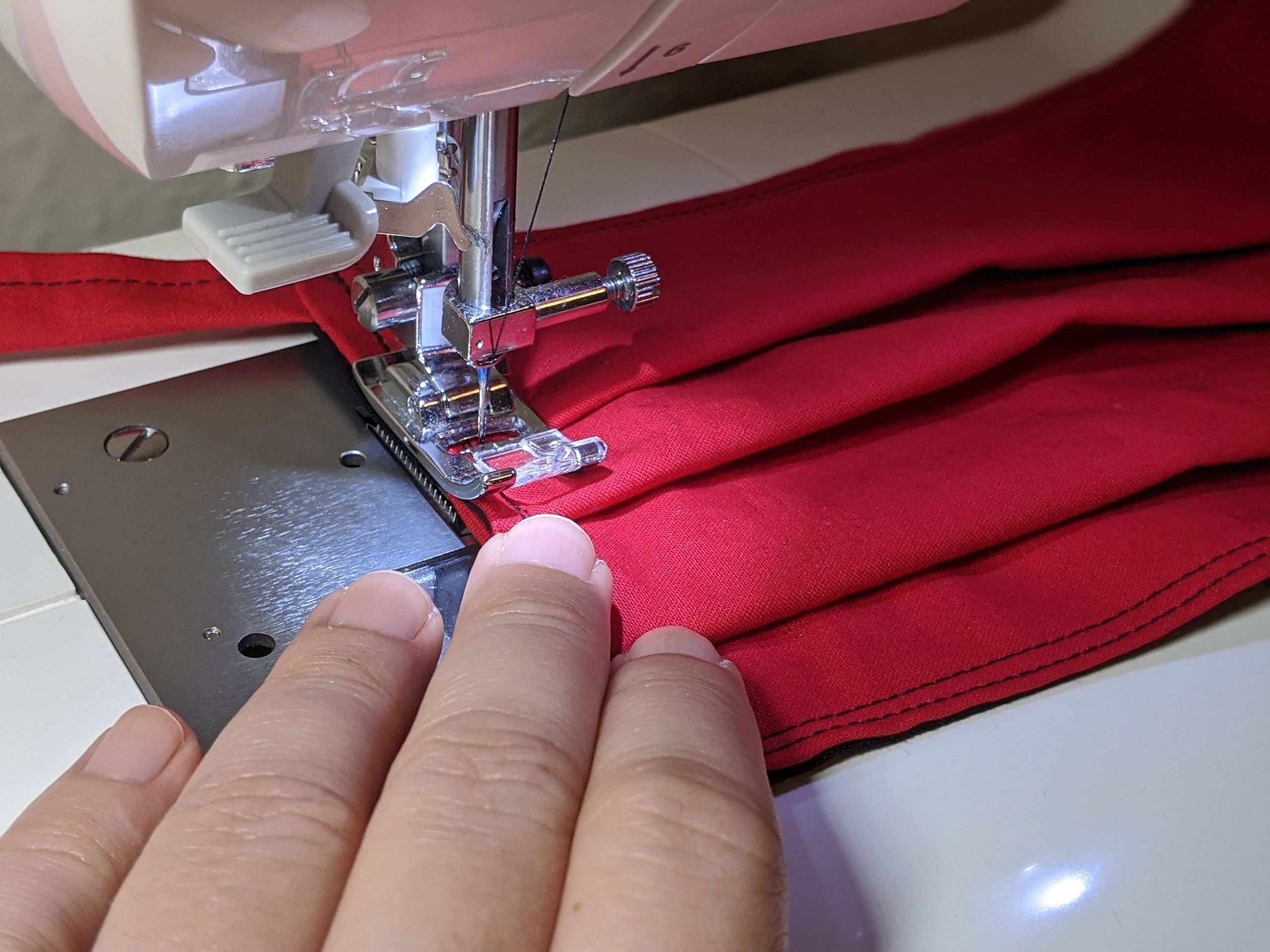 Red mask being sewn