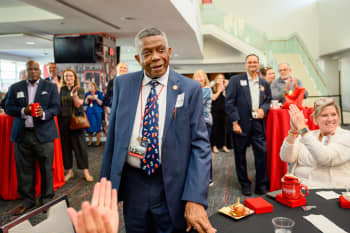 African American man wearing a blue jacket and multicolored tie.