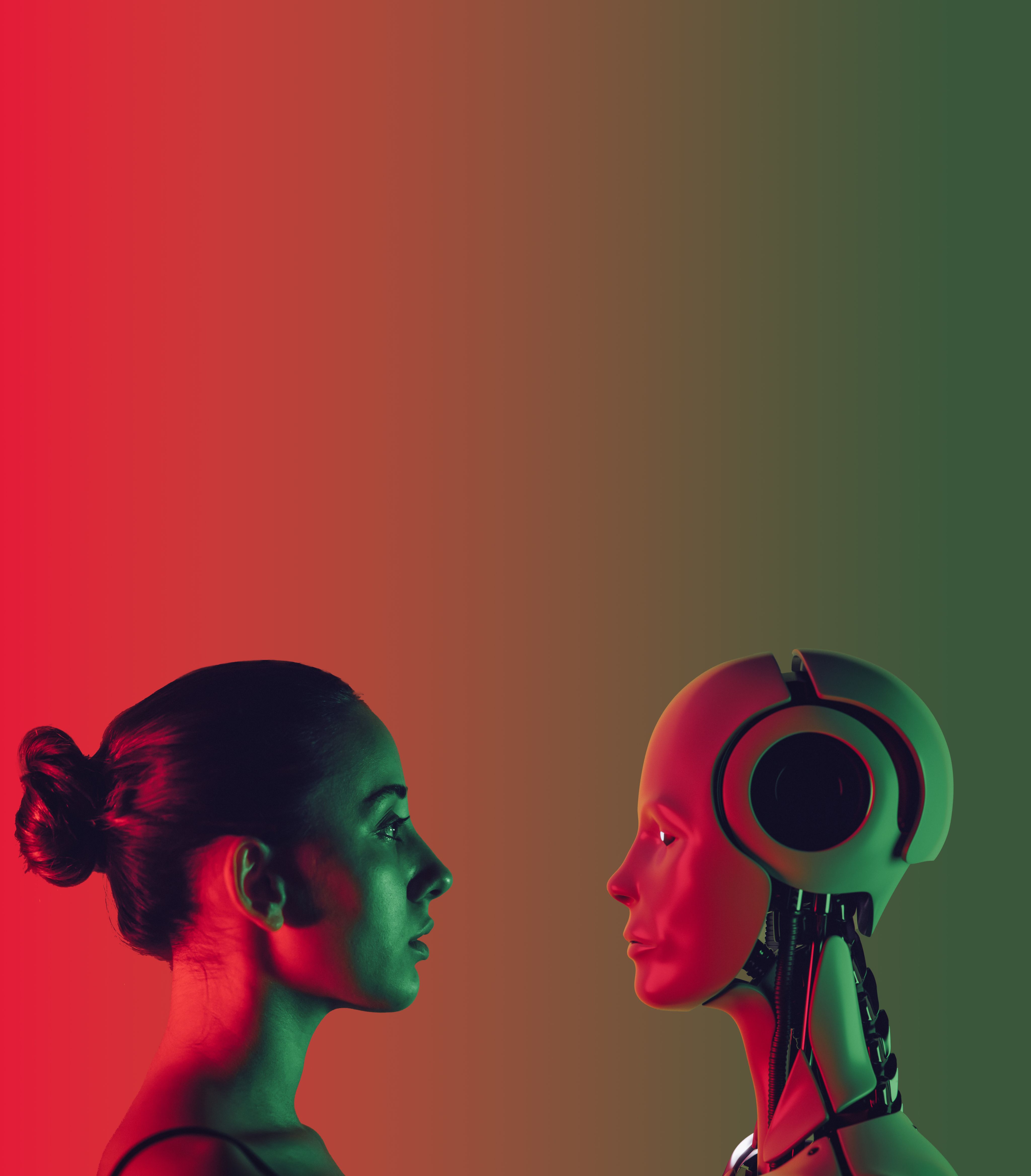 Profile of a woman's head with her hair in a bun looking at the profile of a robot head with a humanoid face. they are in front of a gradient background that fades from red to greeen.