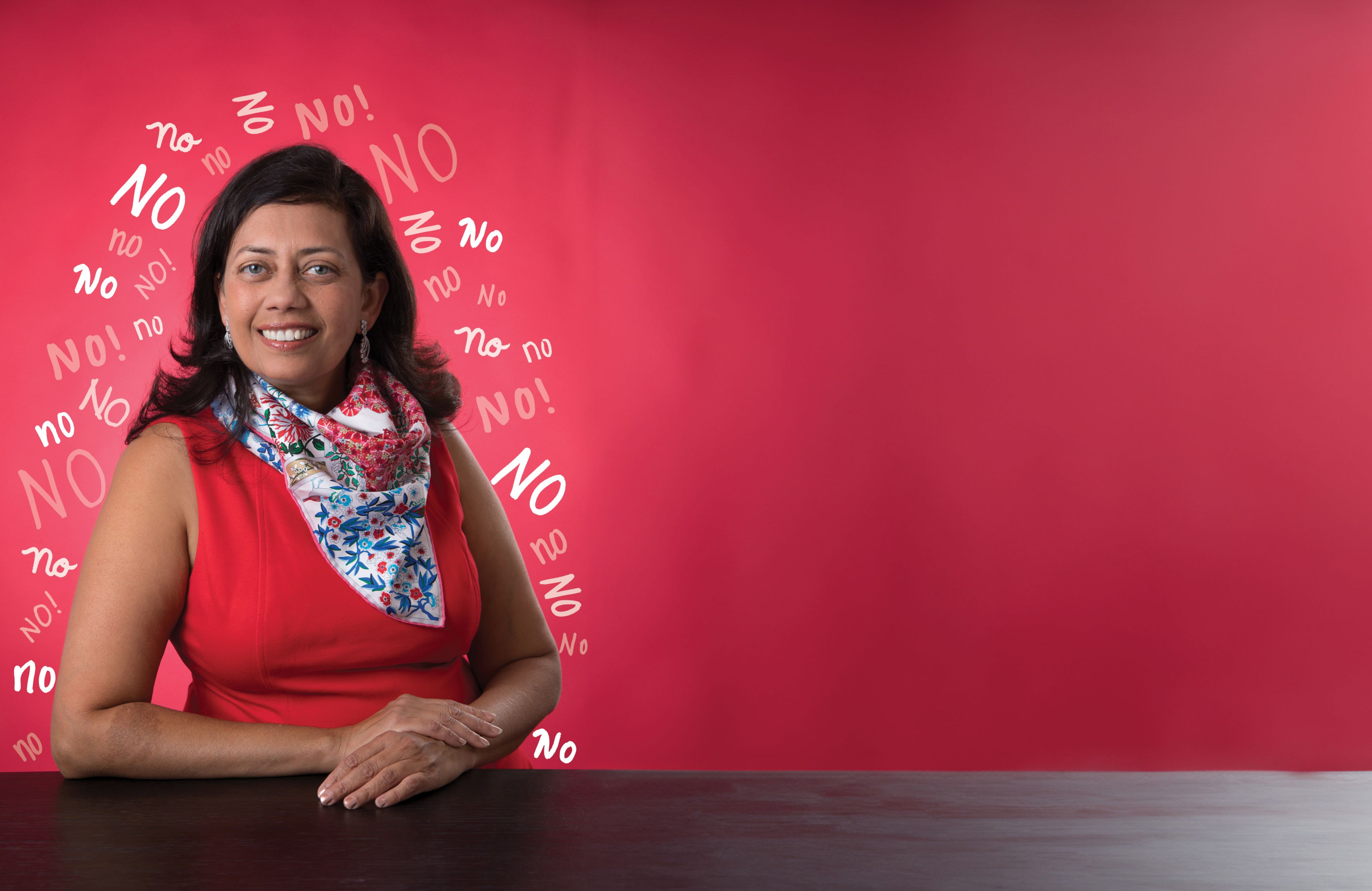 Professor Vanessa Patrick wearing a red sleeveless dress with a colorful scarf. She is in front of a red background and the word "No" is written in multiple styles all around her.