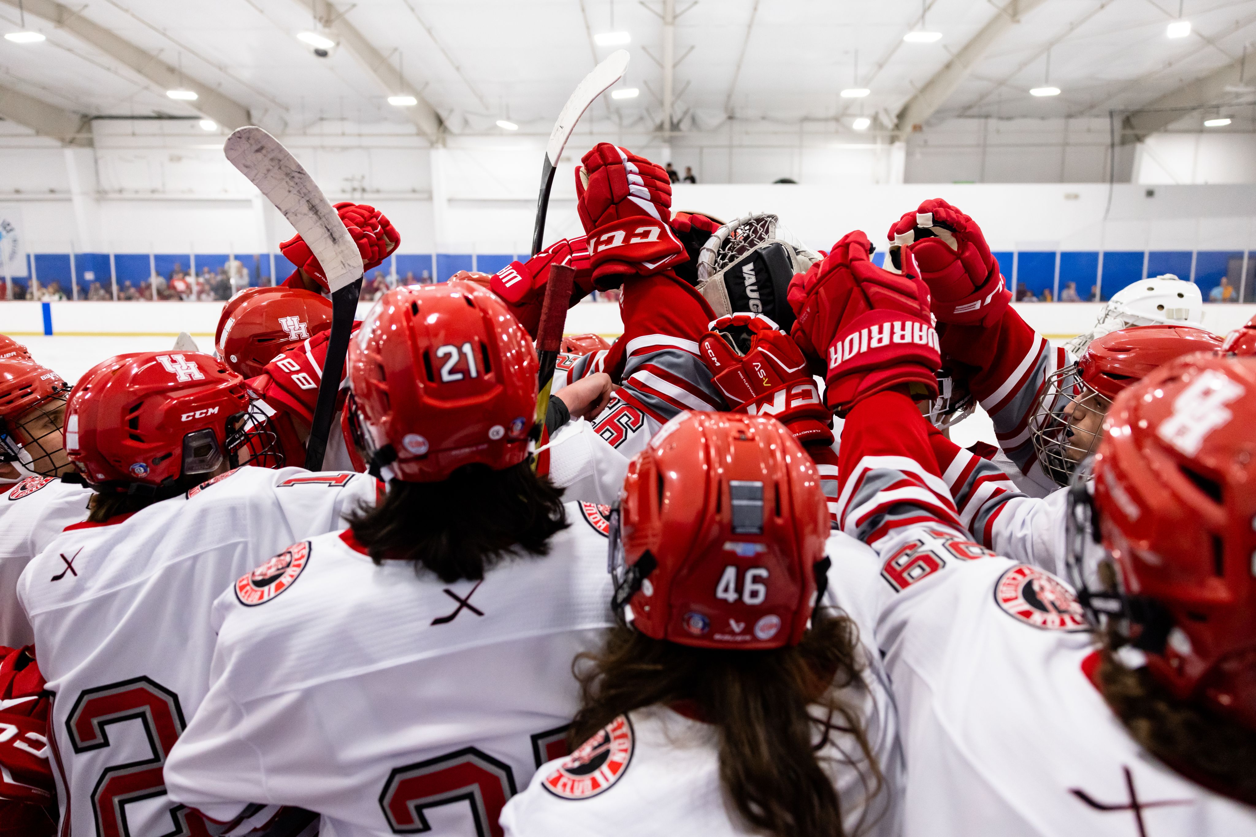 A group of hockey players are huddled together.
