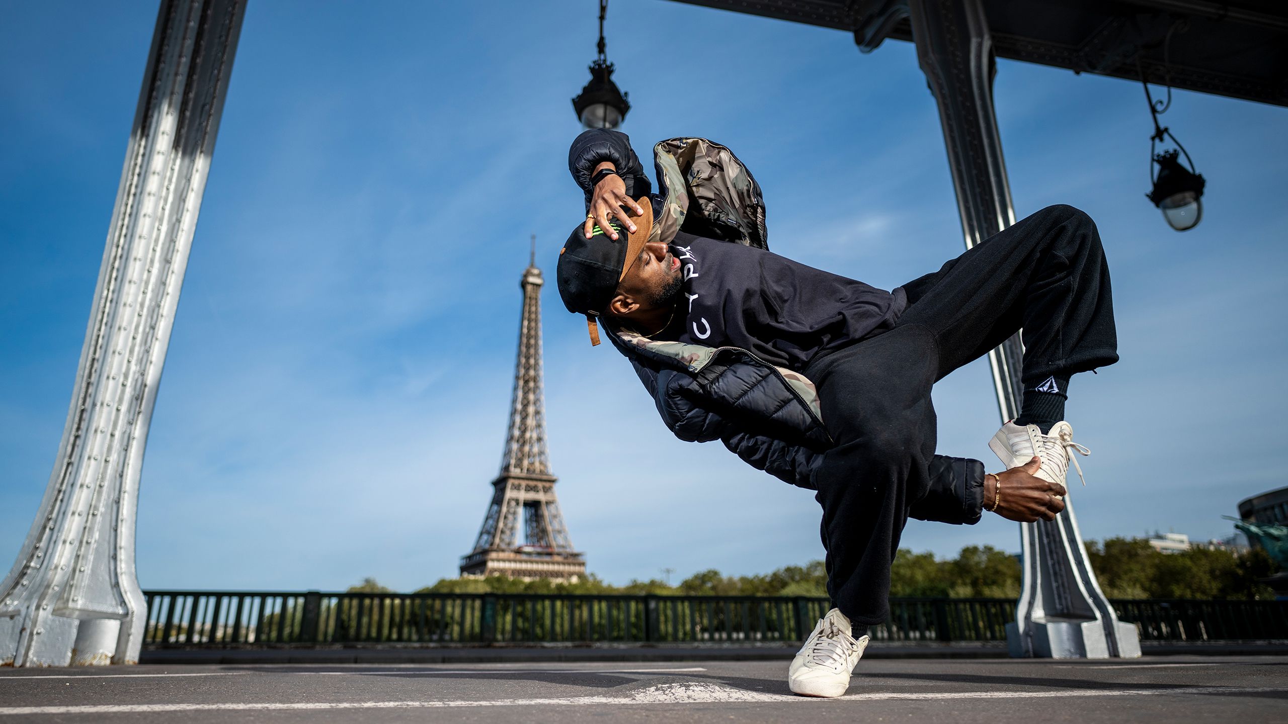 B-boy Jeffro, aka Jeffrey Louis, breakdances with the Eiffel Tower in the background.