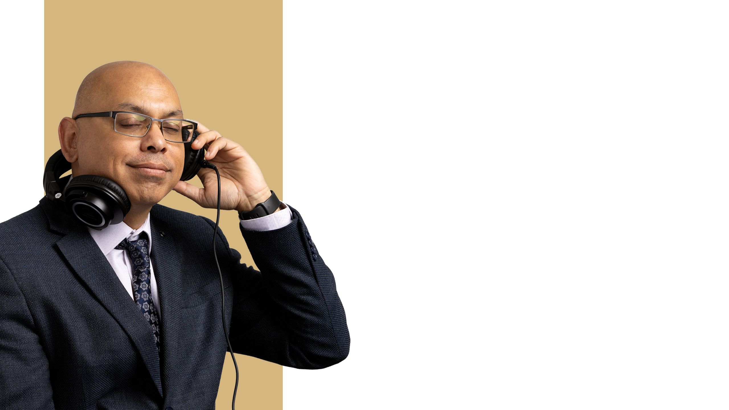 Pradeep Sharma closes his eyes and presses one side of a pair of over-ear headphones to his ear.