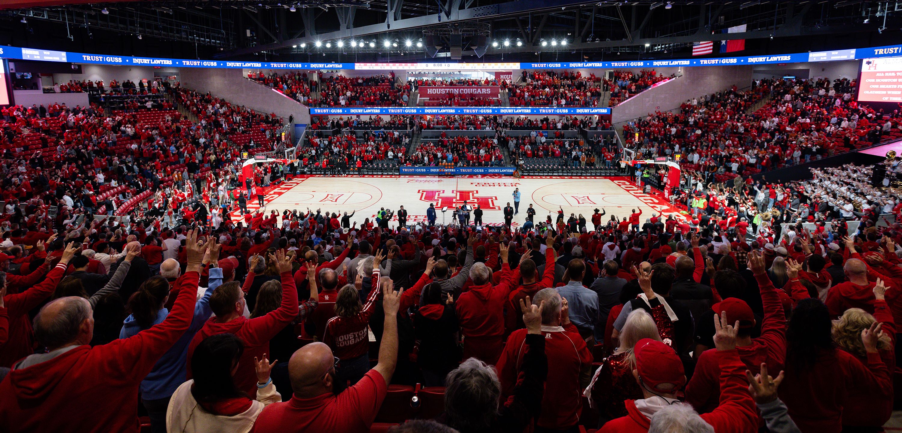 A photograph of a home UH basketball game, with an arena full of UH fans cheering on the team.