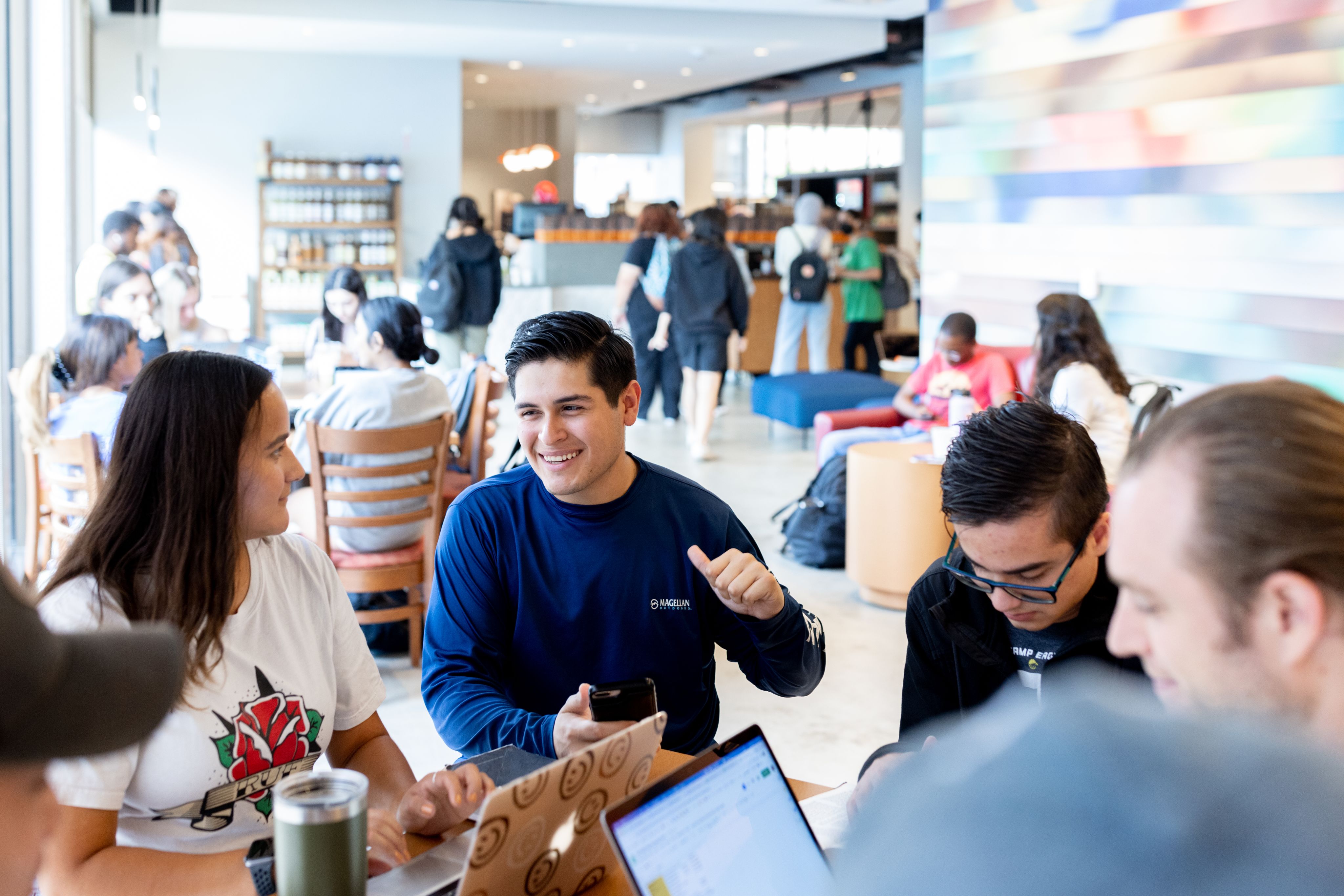 University of Houston student sitting with other UH students in the Cougar Grounds Café.
