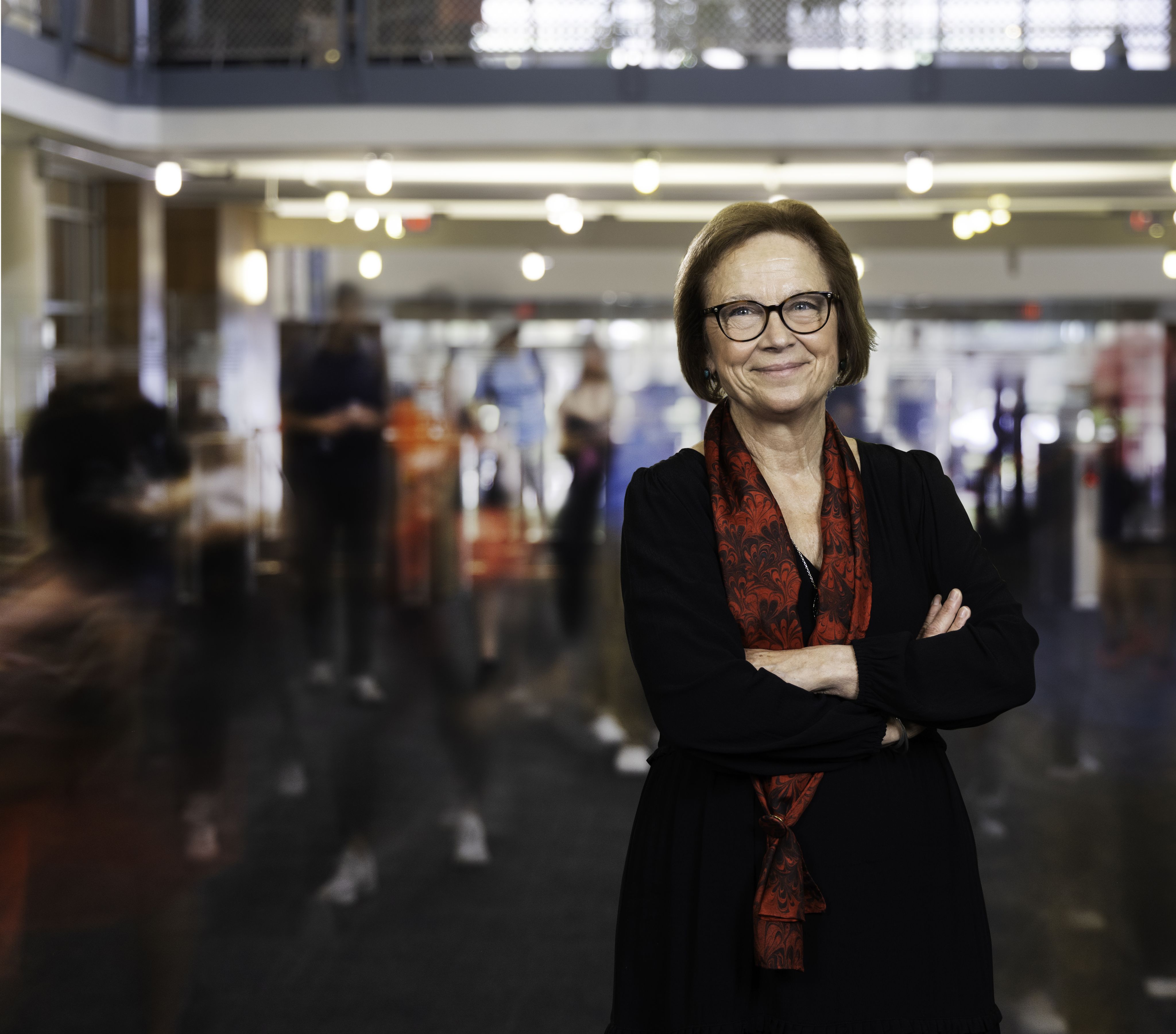 Diane Z. Chase standing in a hallway with her arms crossed.