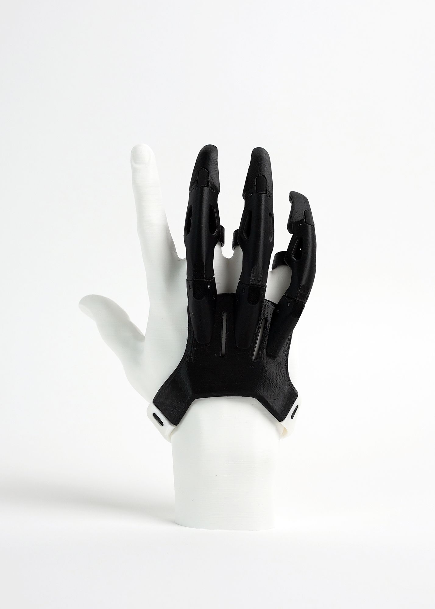 A black, 3D finger prosthesis covers middle, ring and pinky fingers of a model hand.