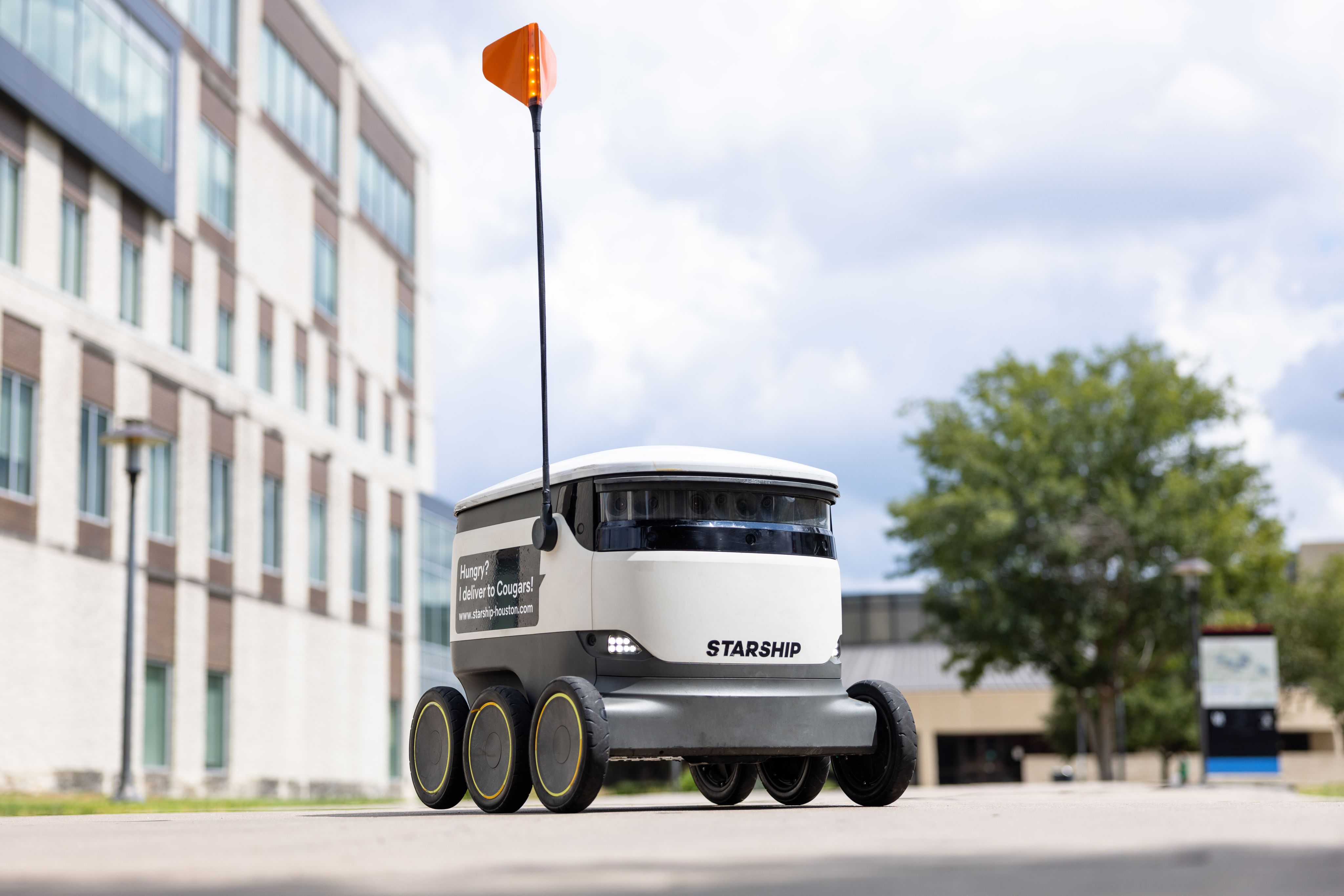A six-wheeled, white, rectangular Starship delivery robots on campus.