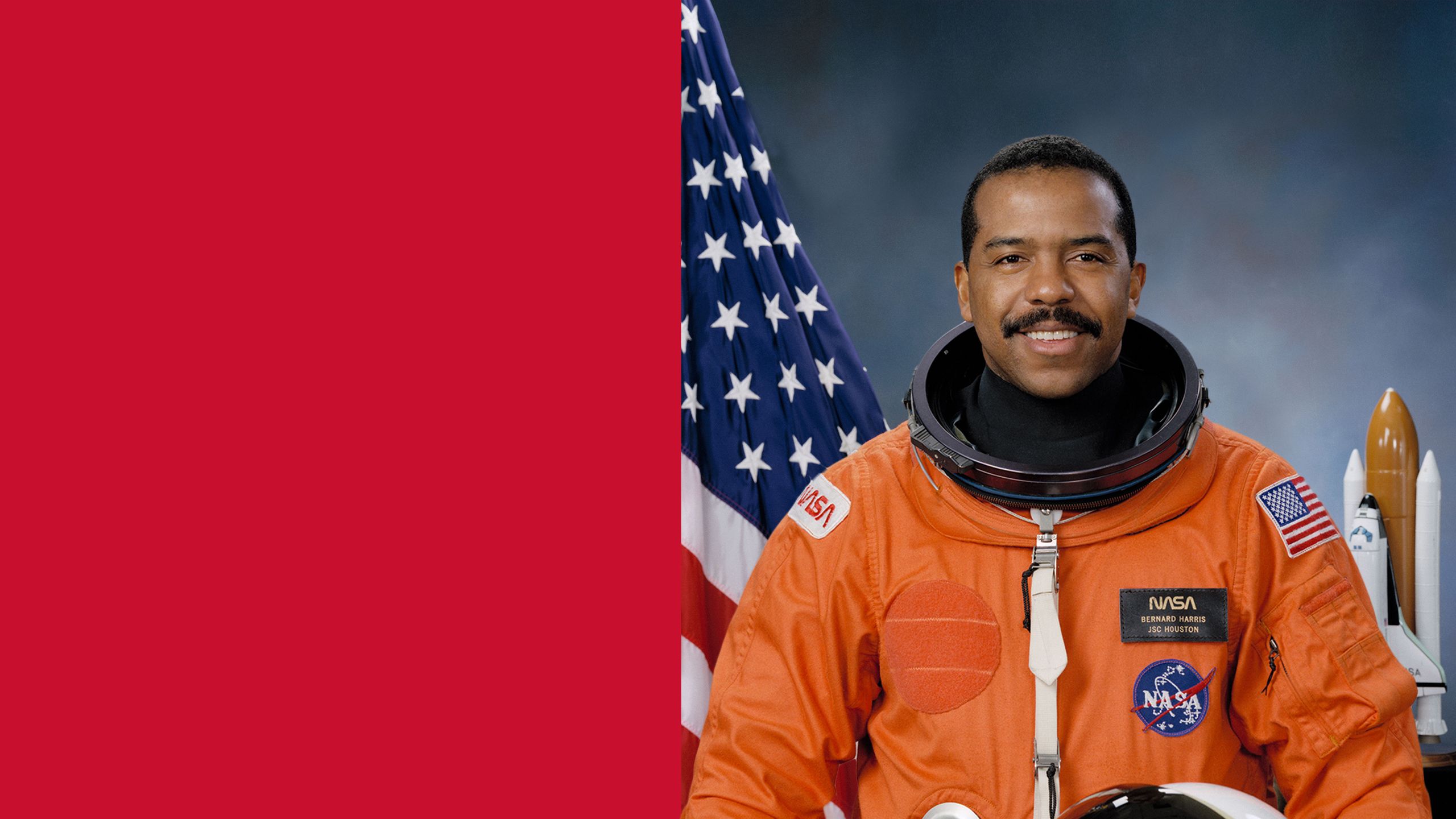 Formal portrait of astronaut Dr. Bernard Harris in an orange space suit holding his helmet