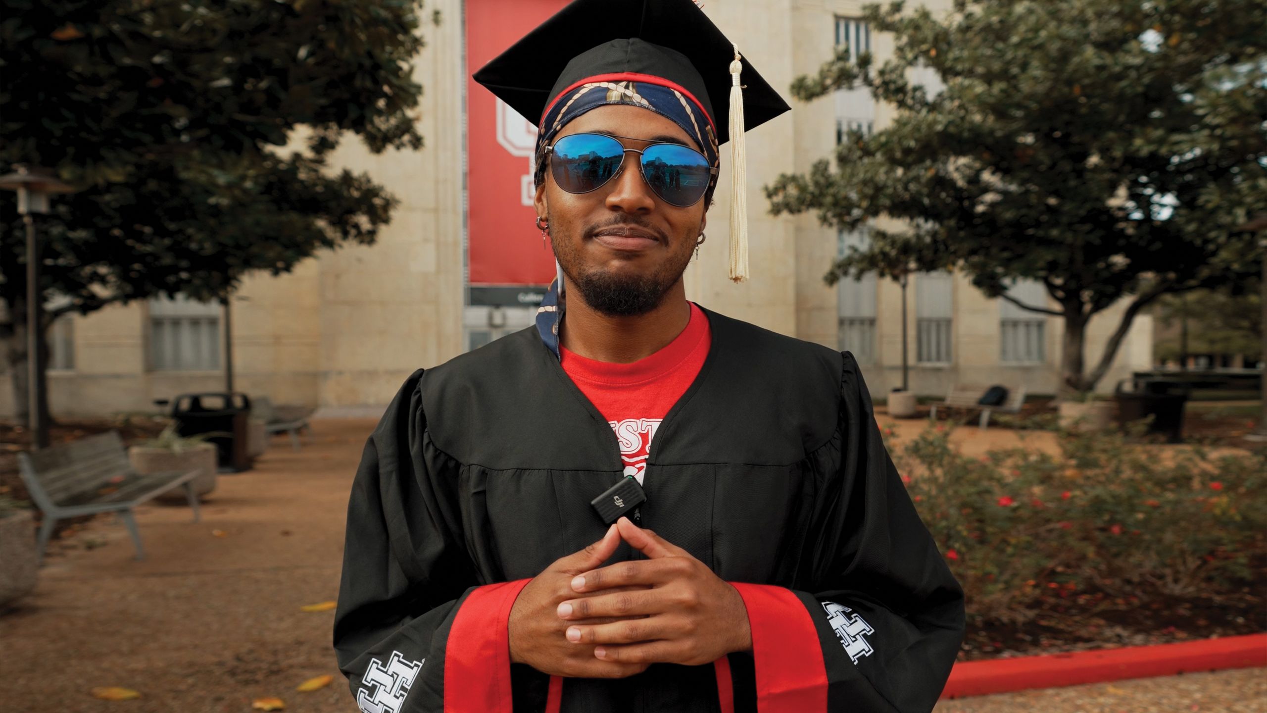 Portrait of Kenneth Cofer III wearing his UH graduation robe and cap.