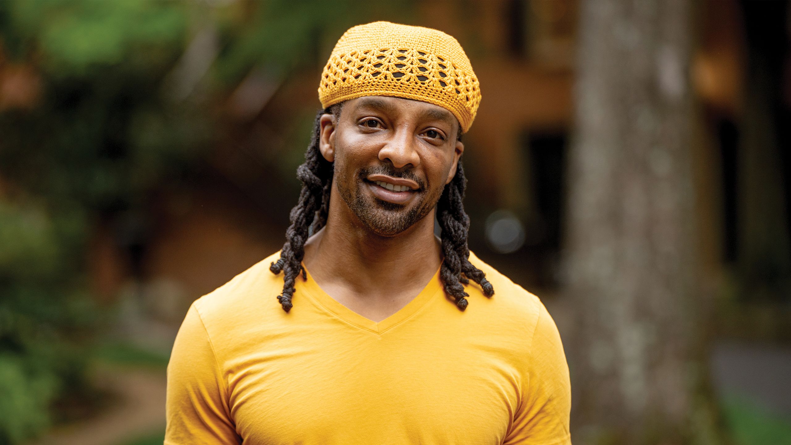 Poet Jericho Brown in a yellow t-shirt and yellow knitted cap