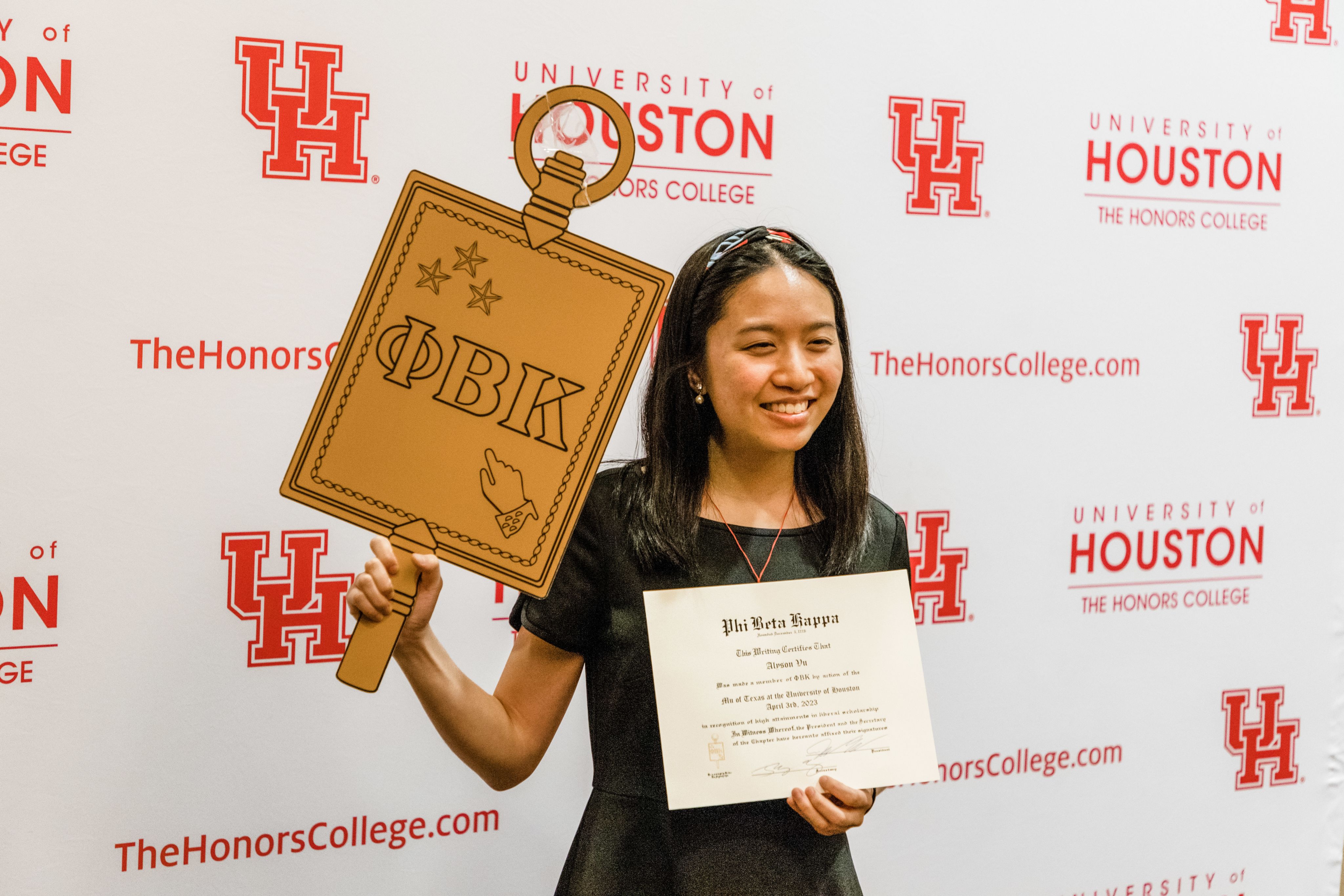 female student holding up certificate